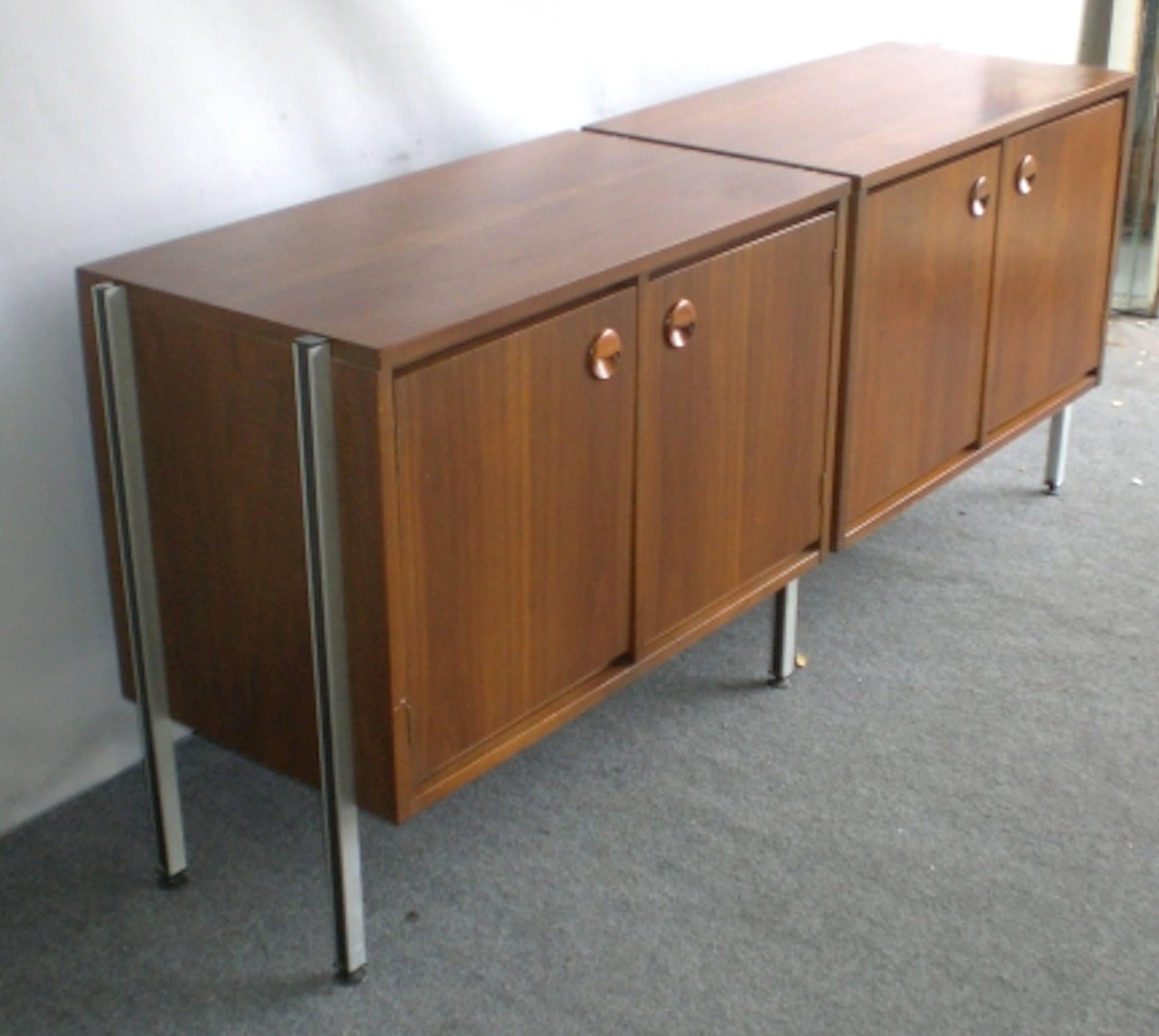 Unusual Mid-Century cabinets attached with metal legs. Two-door cabinets with ample storage and sculpted handles.

(Please confirm item location NY or NJ with dealer).
 
