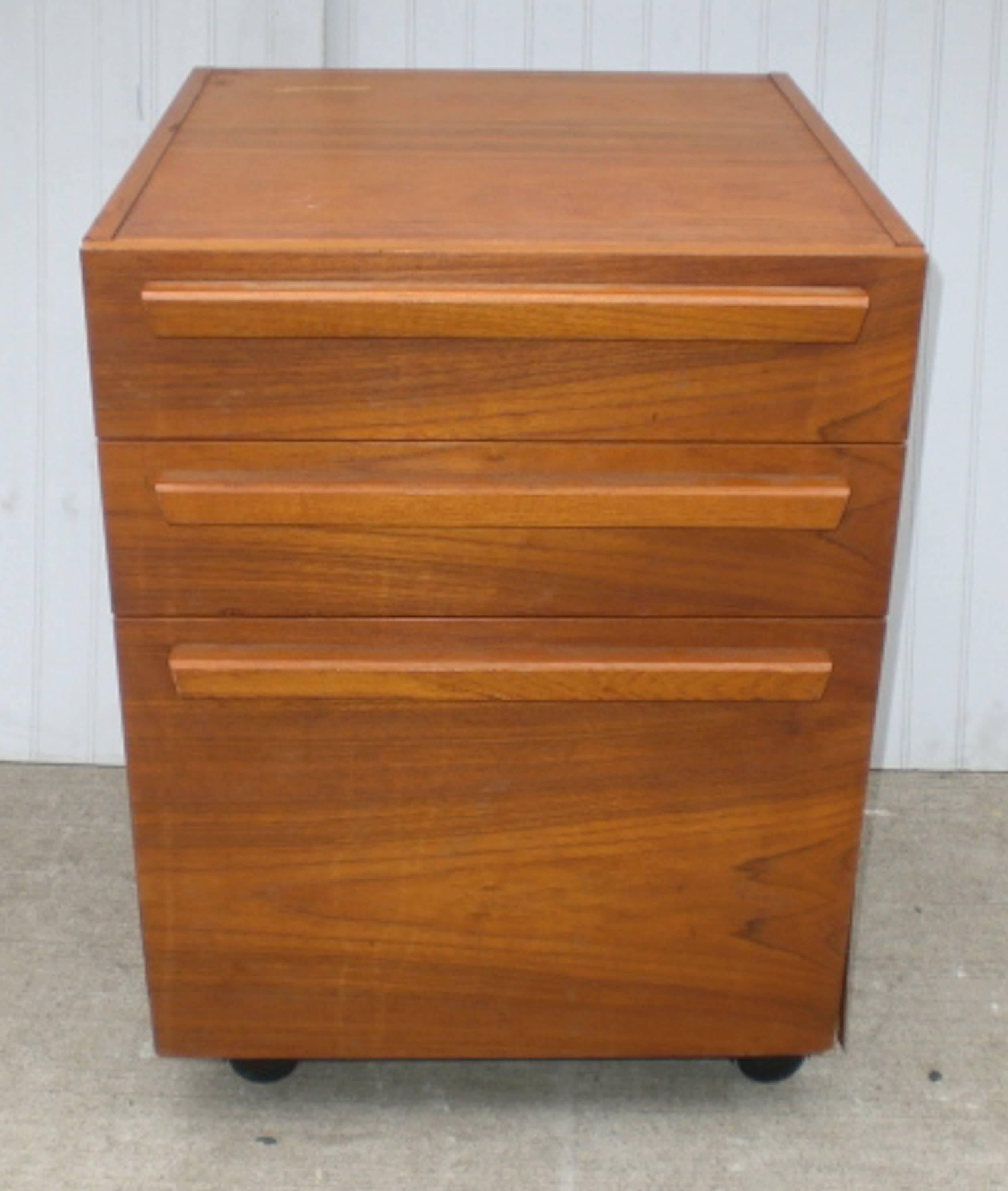 Vintage file cabinet with teak wood grain on casters. Features three drawers and sculpted handles.
Bottom drawer: 14.5 W, 17 D, 10 H.

(Please confirm item location - NY or NJ - with dealer).
 