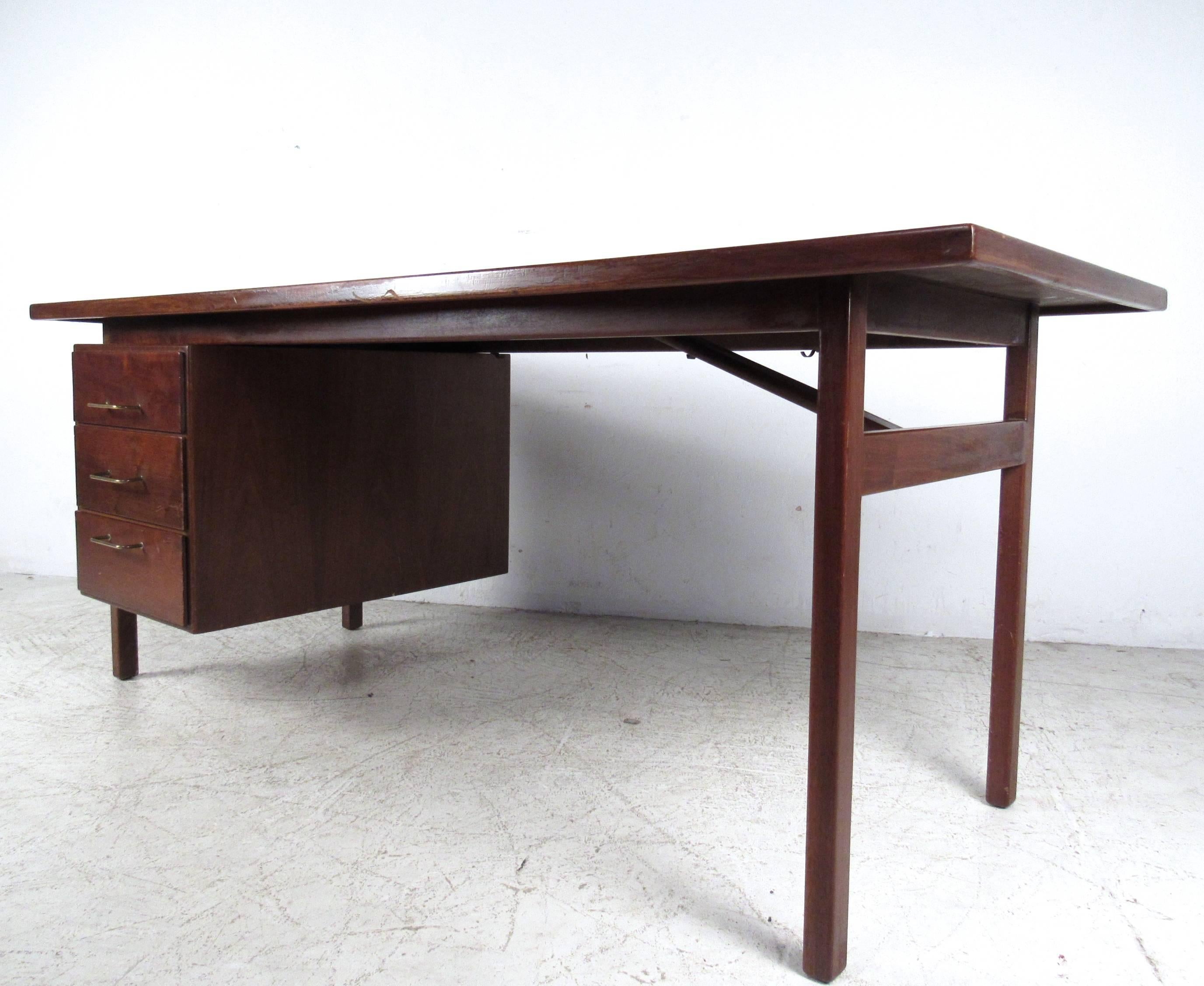 This beautiful vintage writing desk makes a stylish yet simplistic workspace for any interior. With three drawers for storage and added stretchers for support the unique shape of the piece provides ample desk space for home or business. Please