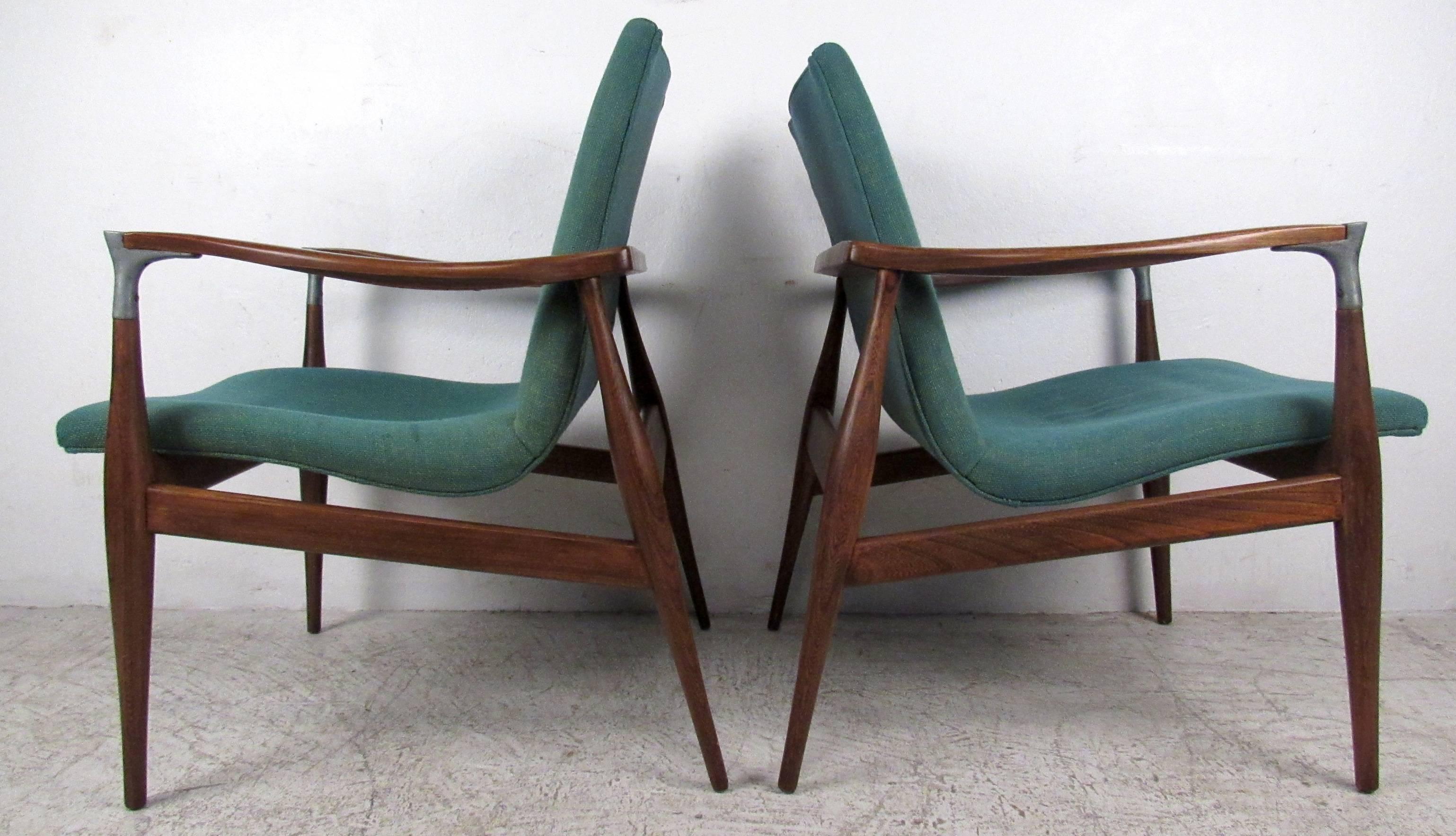 Two vintage-modern walnut side chairs featuring floating seat, sculpted armrests with metal trim and upholstered seats.

Please confirm item location NY or NJ with dealer.