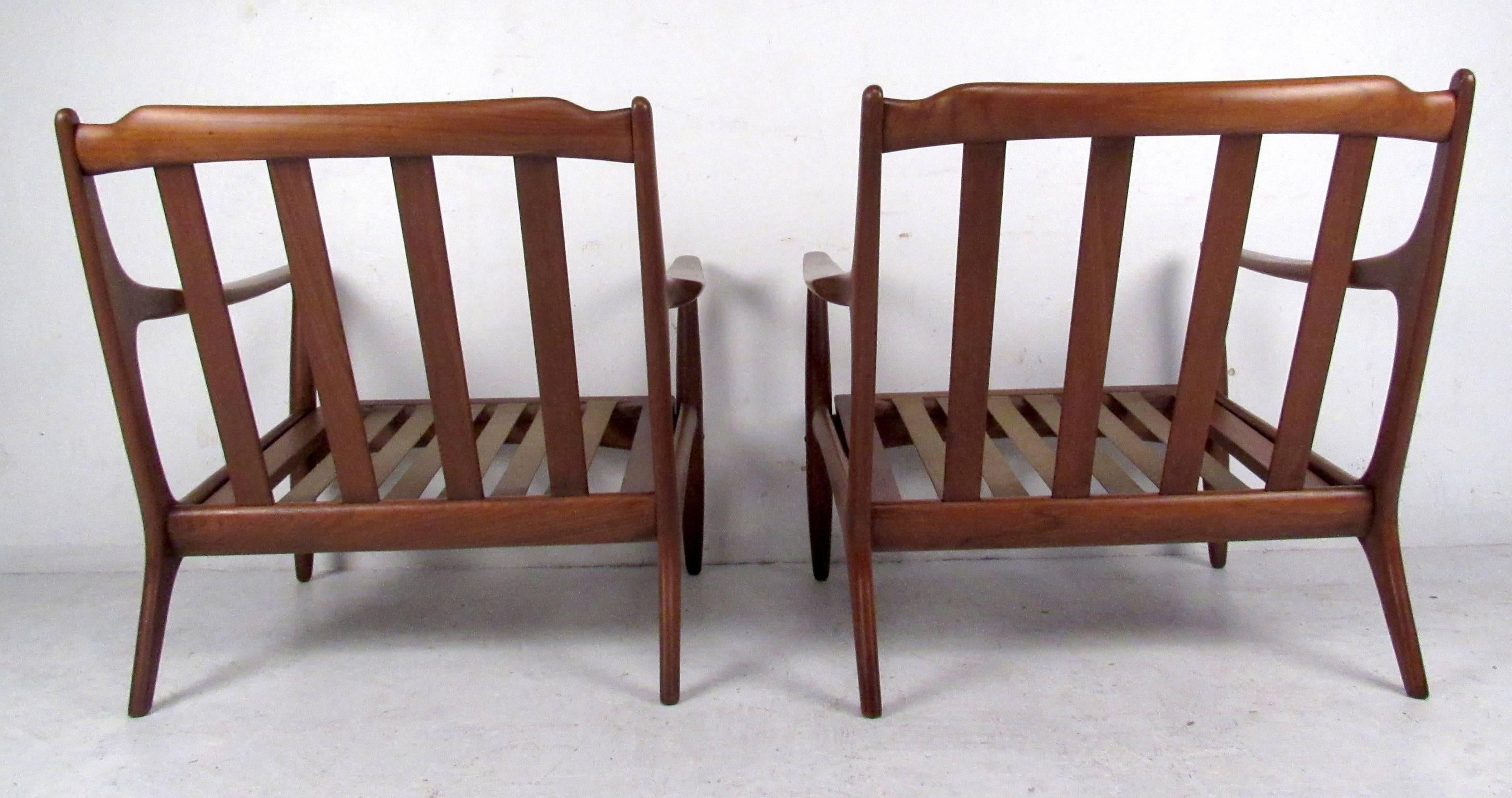 Two vintage-modern lounge chairs featuring sculpted body with rubber straps along seat, made in Denmark.

Please confirm item location NY or NJ with dealer.