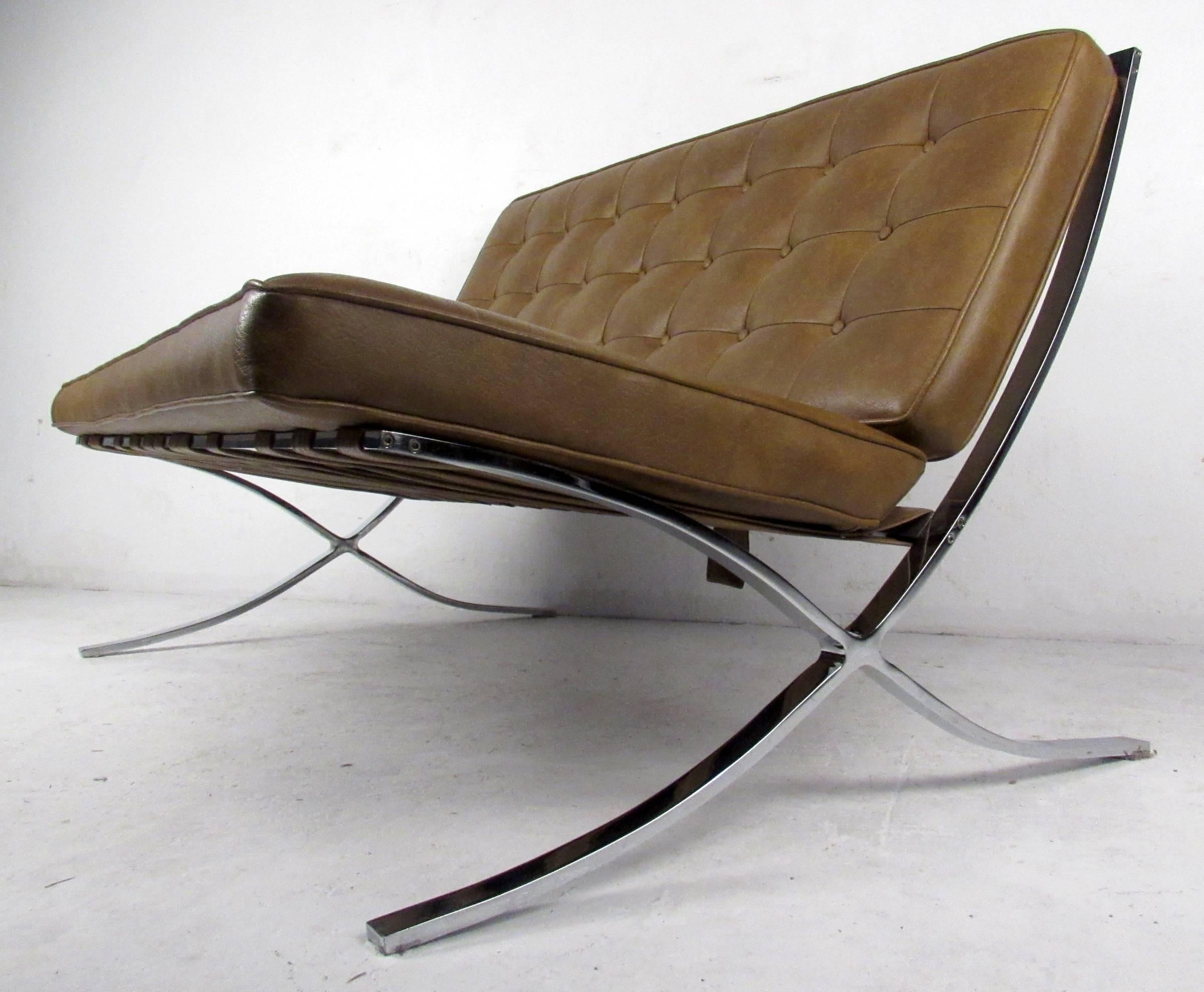 Vintage-modern Barcelona style settee featuring tufted vinyl upholstery and beautifully sculpted chrome base. Striking two seat sofa perfect for home or business seating arrangement in the mid-century style of mies van der rohe for Knoll. 

Please