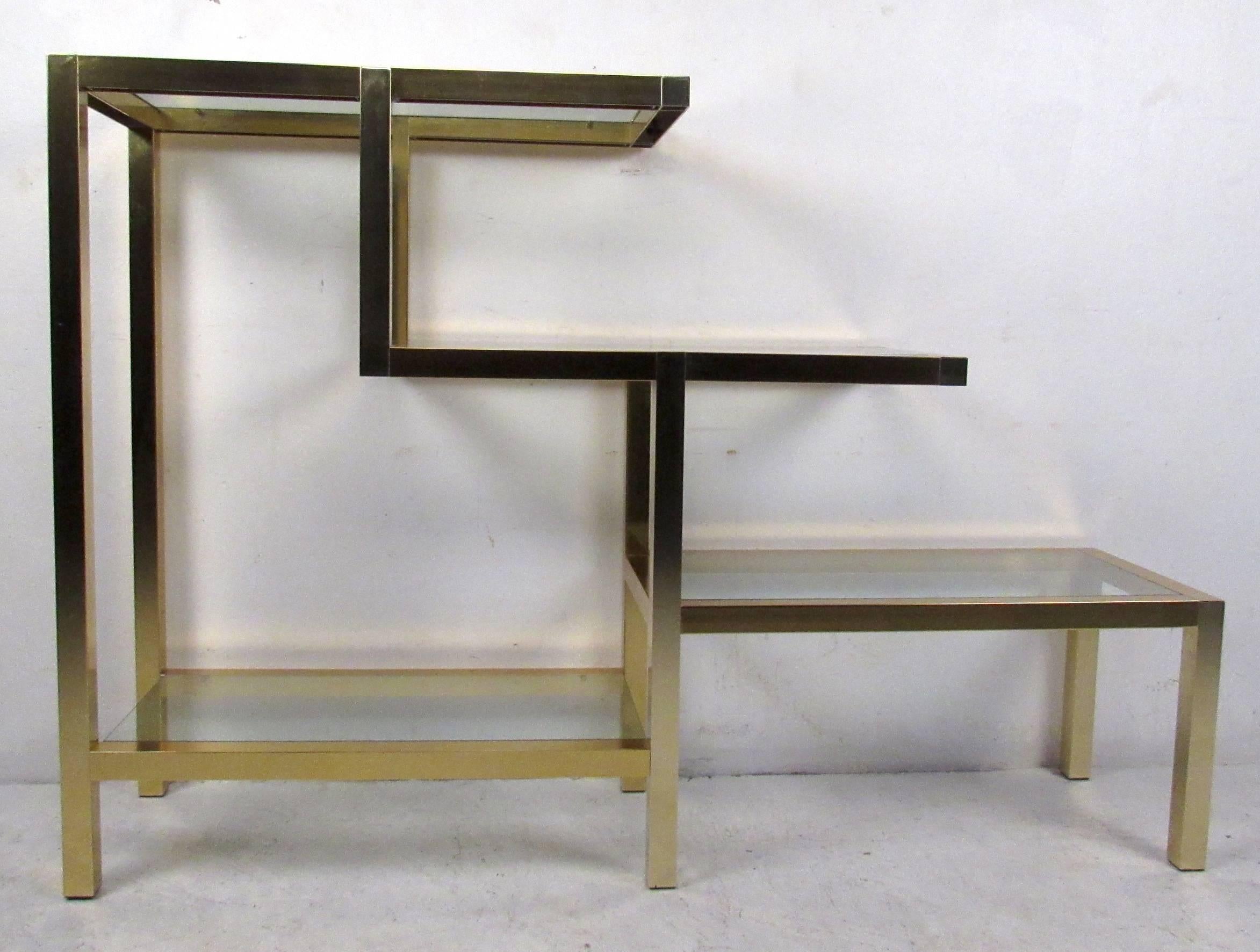 Vintage-modern Milo Baughman style bookcase featuring sculpted body with brass finish and four glass shelves. Stunning display shelf for home, office, or business use.

Please confirm item location NY or NJ with dealer.