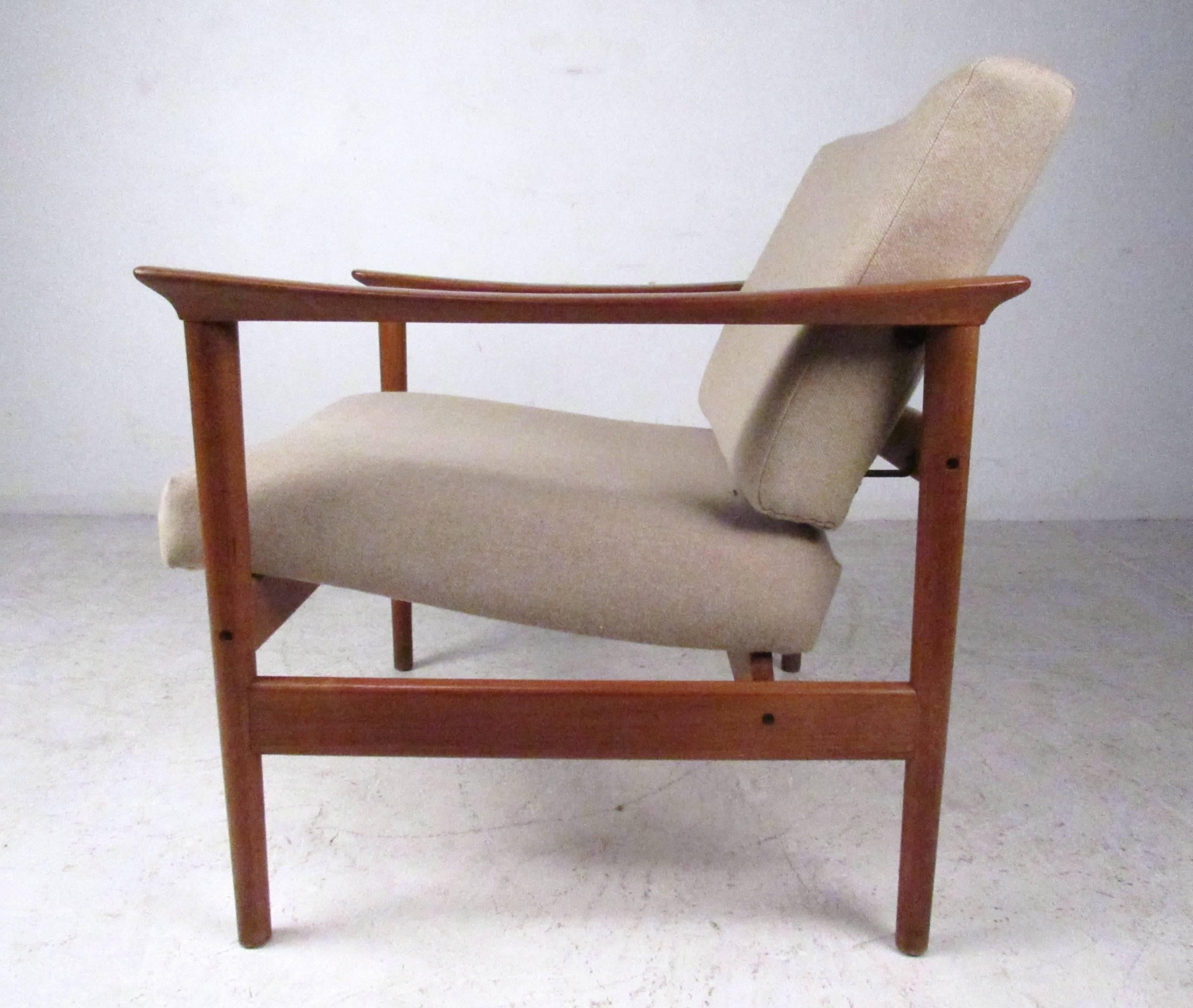 This stylish vintage lounge chair features the perfect mix of style and comfort in a stunning Mid-Century design. Sturdy construction includes a tapered teak frame with carved armrests, making this a wonderful addition to any seating arrangement.