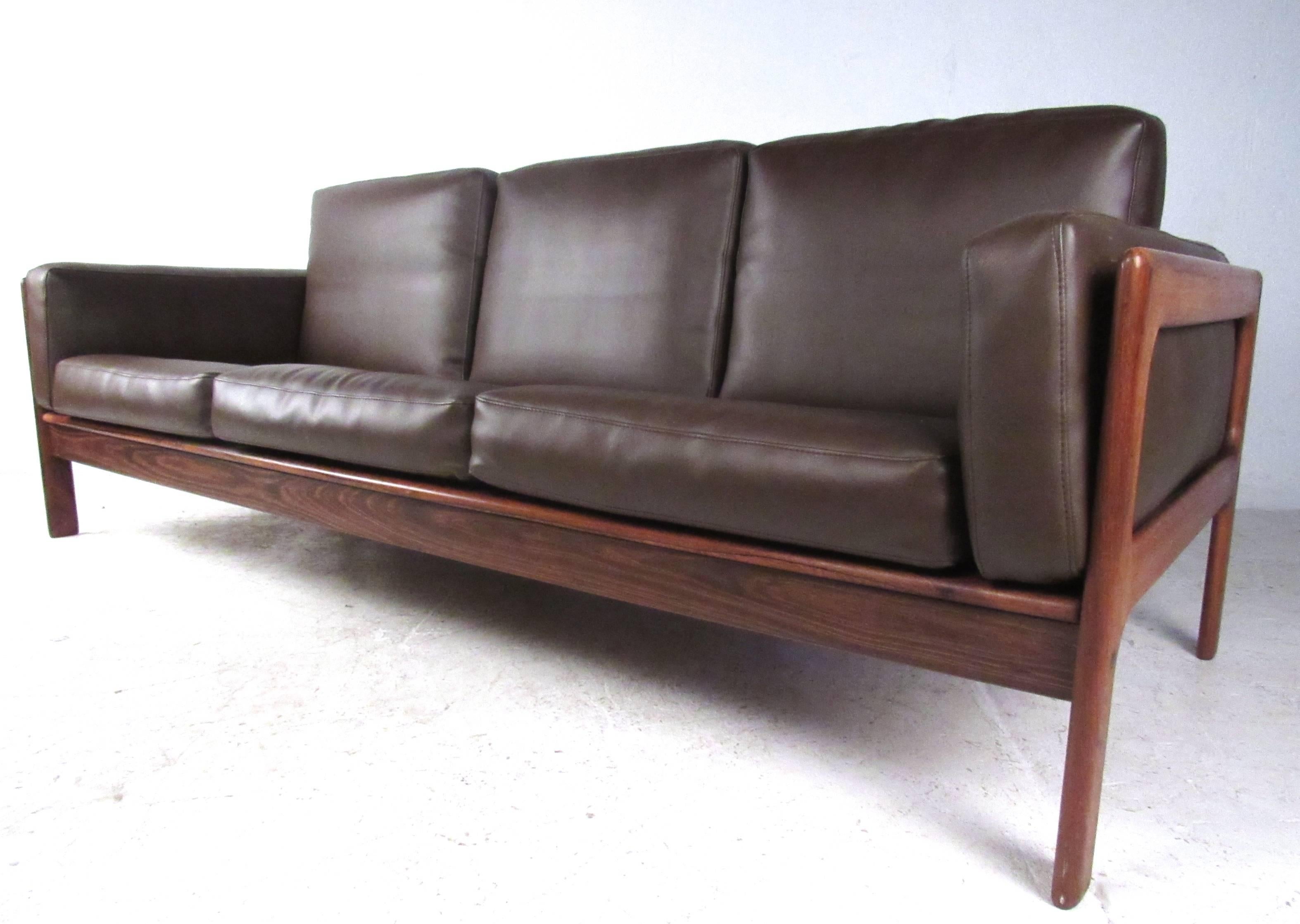 This beautiful vintage sofa features a deep rosewood finish, quality vinyl upholstery and a sleek low-profile design. Comfortable yet stylish seating for a variety of interiors, please confirm item location (NY or NJ).