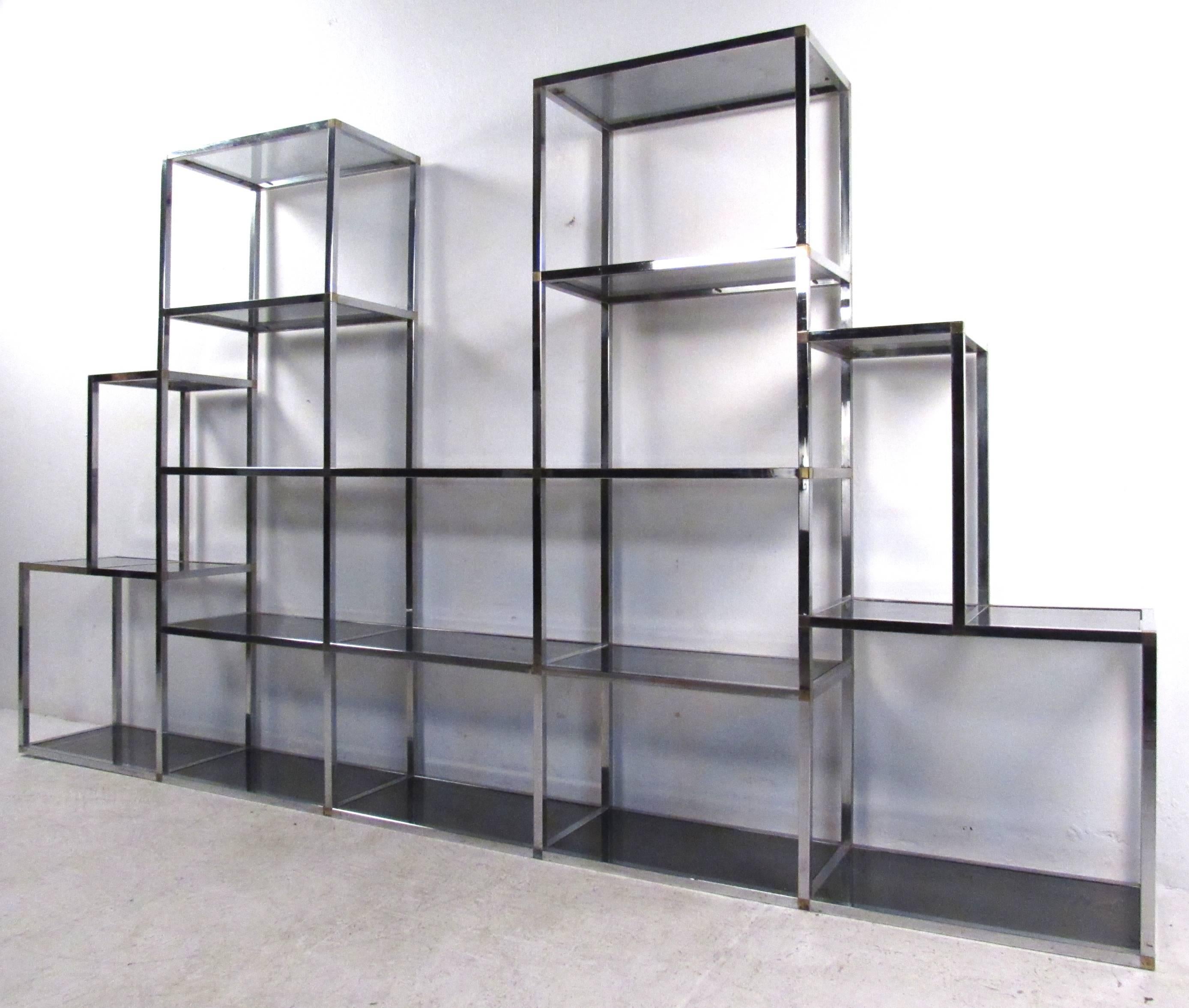 This large and impressive Mid-Century chrome and glass etagere features a unique layout, with staggered smoked glass shelves perfect for home or shop display. Excellent storage piece makes a wonderful addition to any interior, home or business.