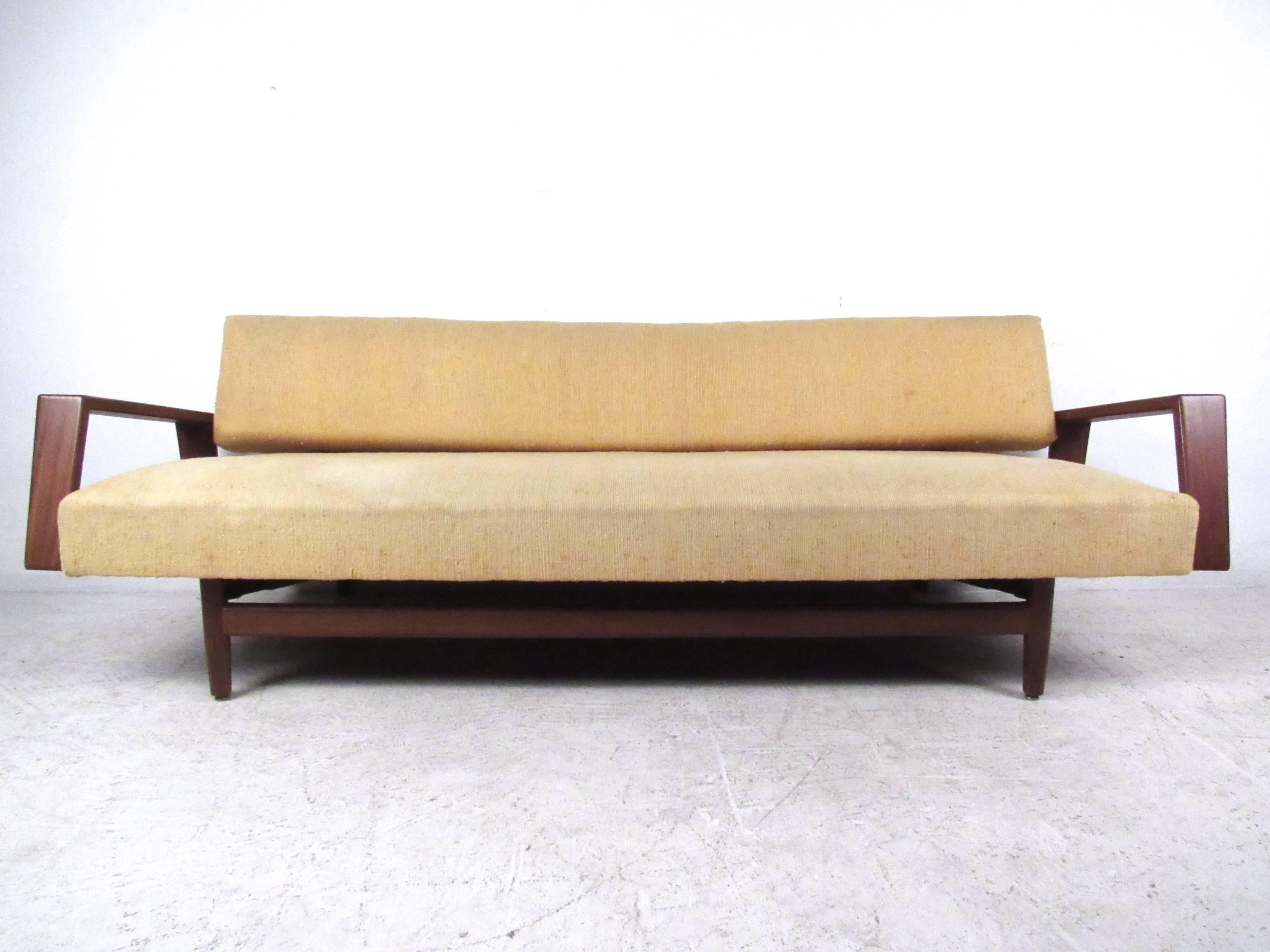 This unique vintage sofa offers comfortable seating in a stylish package. Wide sculpted armrests and tapered leg stretchers add to the style of the piece, making it a great sofa for any setting. The piece allows for daybed style extension, opening