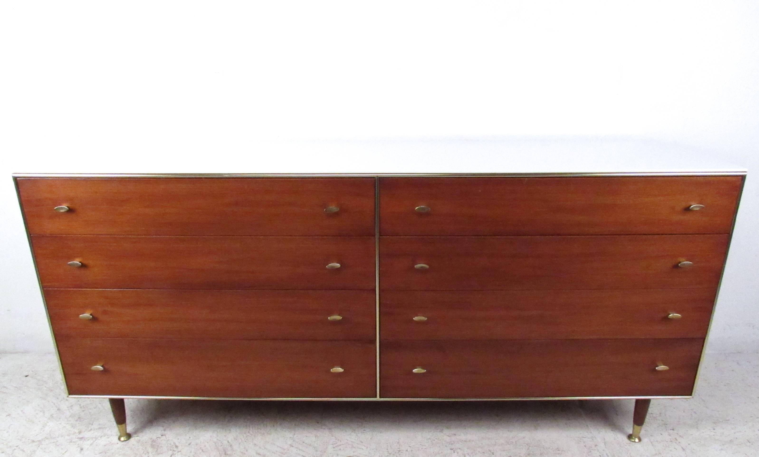 This unique eight-drawer dresser by R-Way of Sheboygan, WI offers plenty of storage in a stylish package. Brass handles, feet, and trim are wonderfully offset by a deep reddish walnut finish. White glass rests on top for added durability and a