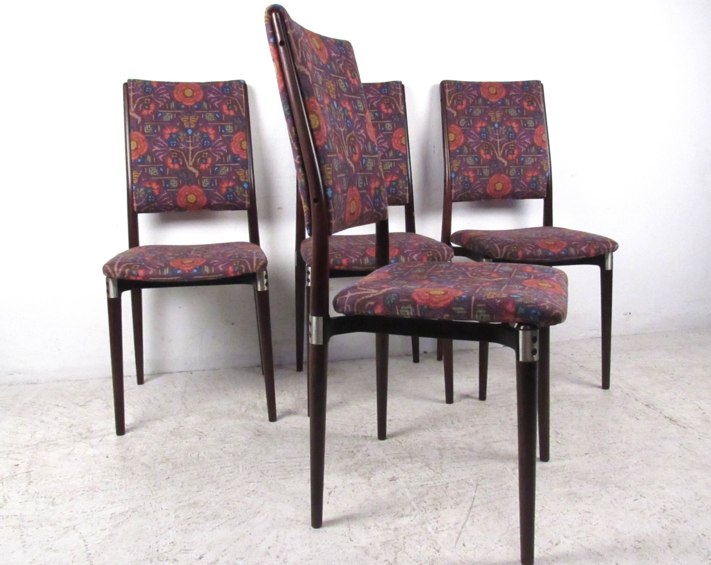 Cet ensemble unique de chaises de salle à manger à haut dossier présente une merveilleuse combinaison de rembourrage design élégant et de cadres en bois uniques. Les pieds effilés, les garnitures en aluminium et le tissu vintage en font un ajout
