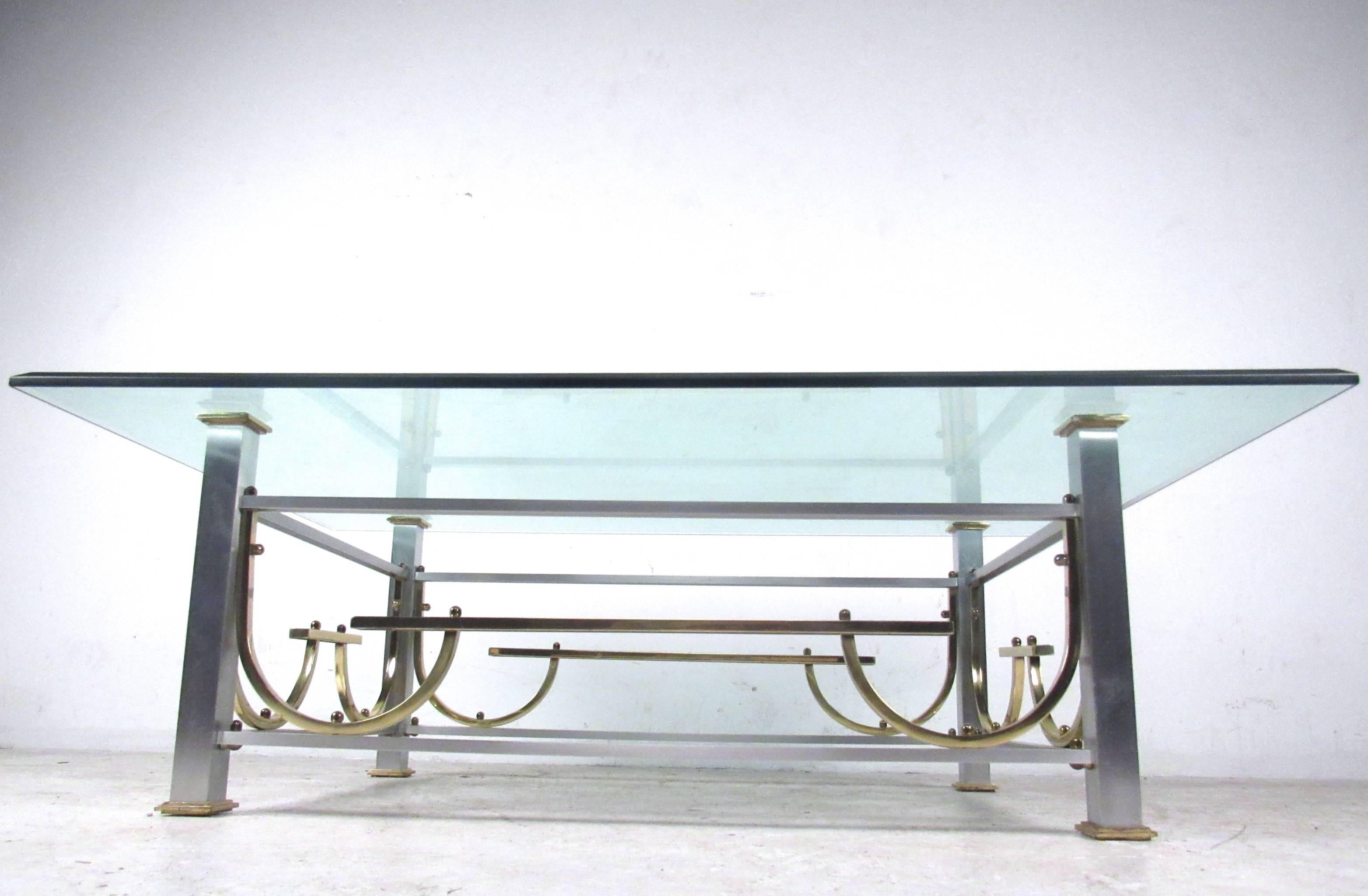 This unique vintage coffee table features a stylish vintage base with four post design, beveled glass and brass trim. Great table for a variety of modern interiors, please confirm item location (NY or NJ).