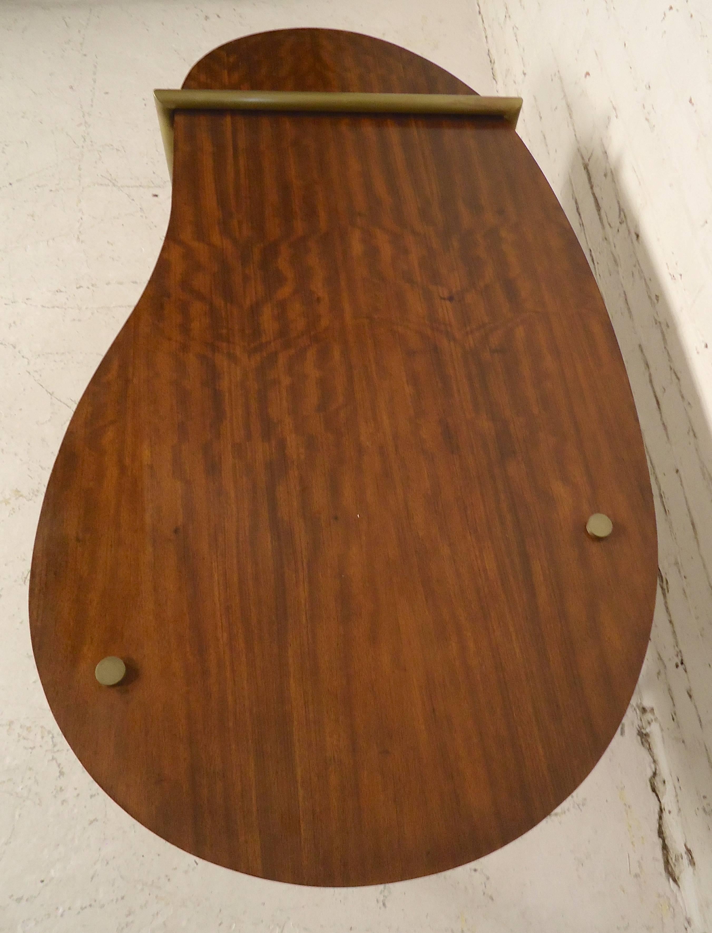 Mid-Century Modern style table with asymmetric top in hyedua wood grain, set above a tubular brass frame. 

(Please confirm item location - NY or NJ - with dealer).
 