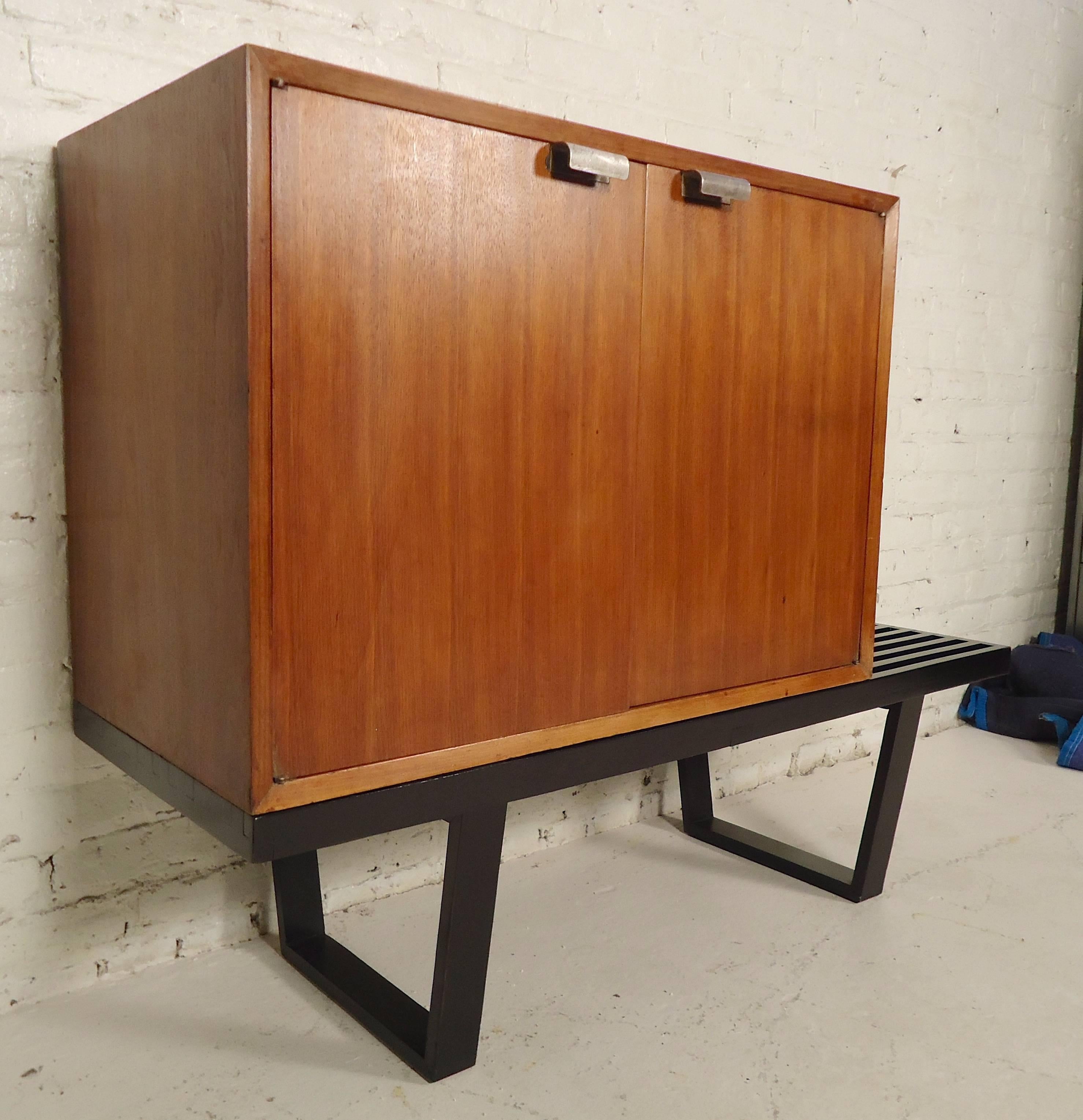 Mid-Century Modern storage cabinet set on a refinished black slat bench. Cabinet can be removed or re-positioned on bench, adjustable shelf, metal door pulls.
Cabinet: 34