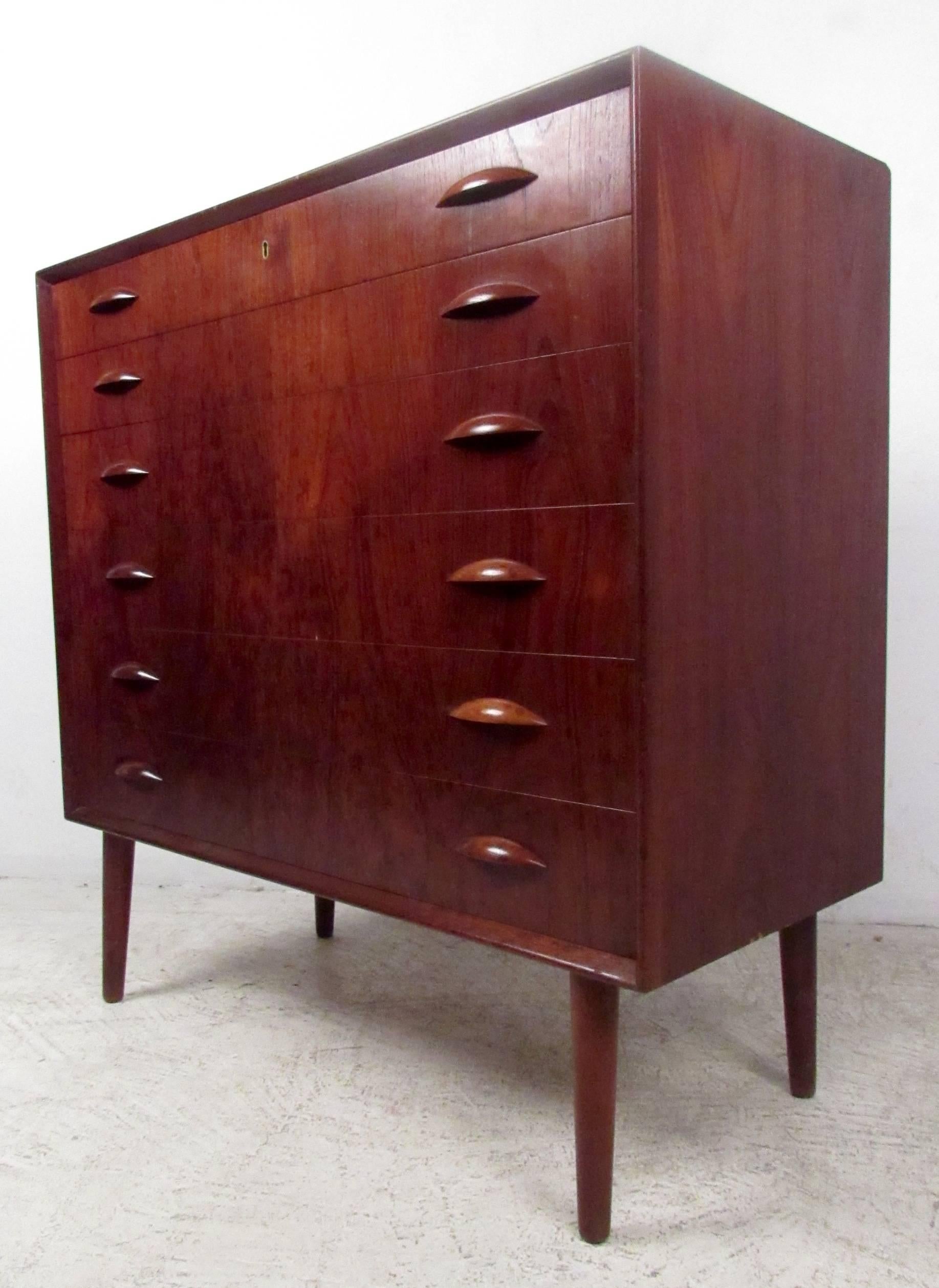Vintage teak Kai Kristiensen highboy dresser featuring sculpted handles and tapered legs. Iconic Scandinavian Modern design makes this the perfect storage dresser for any bedroom. Please confirm item location (NY or NJ.)

