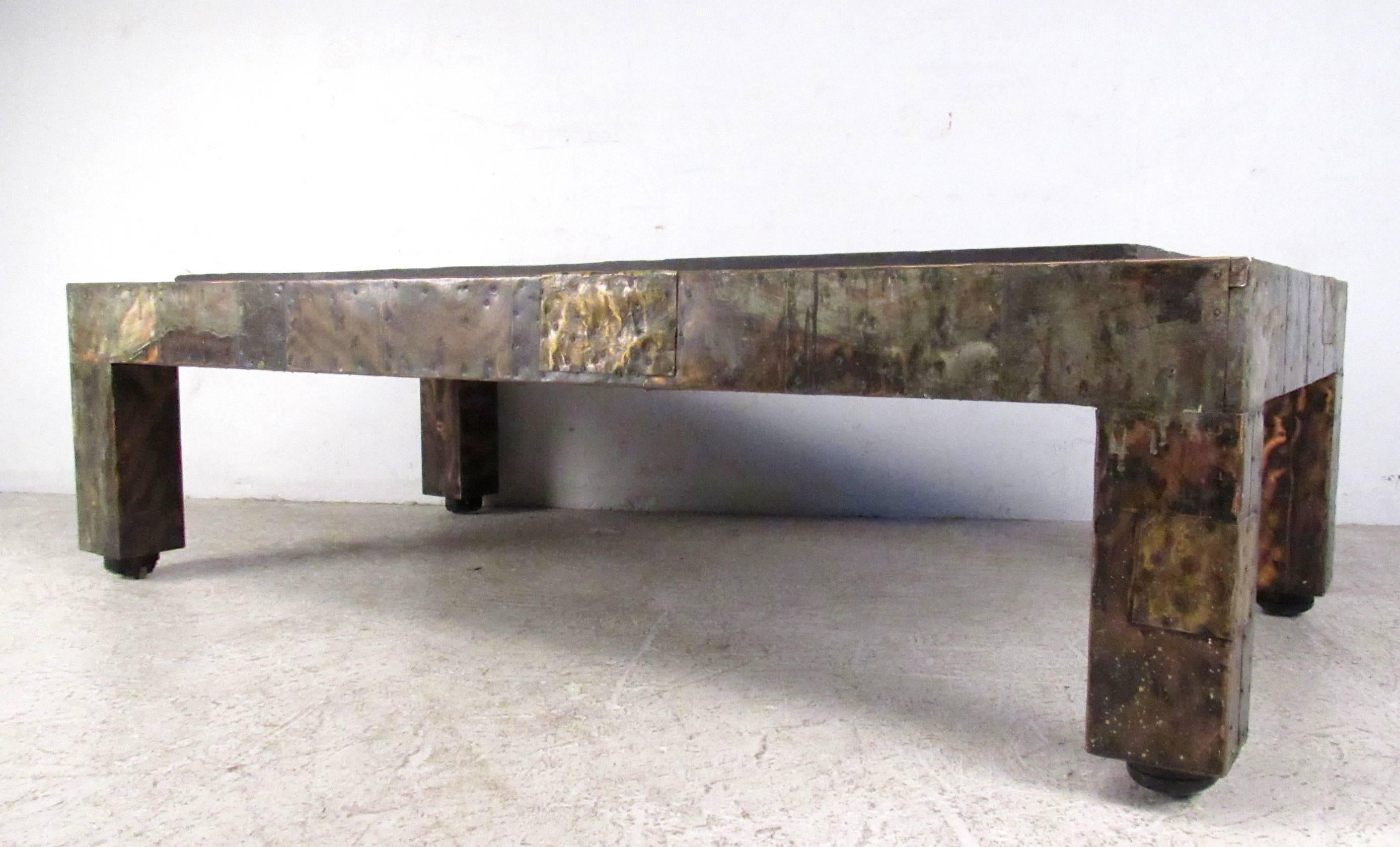 This stunning Mid-Century table uses a combination of patchwork hammered metal to create a stunning effect. Vintage slate top wonderfully compliments the piece, while low profile casters make it easy to move. Please confirm item location (NY or NJ).