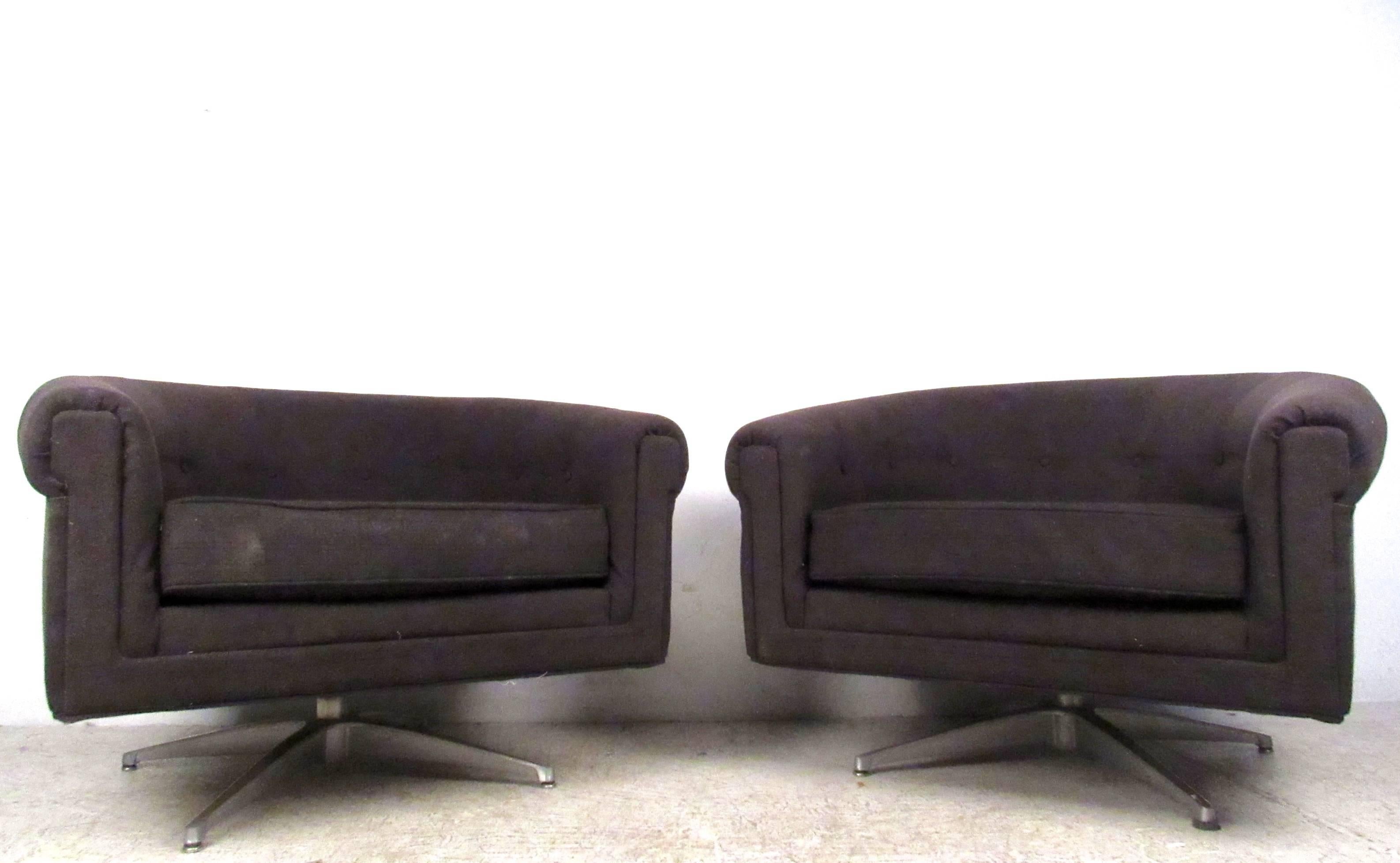 This comfortable pair of swivel style lounge chairs by Selig make a stylish addition to any setting. Rounded back seats with sturdy metal bases, this unique matching pair is perfect for home or office. Please confirm item location (NY or NJ).
