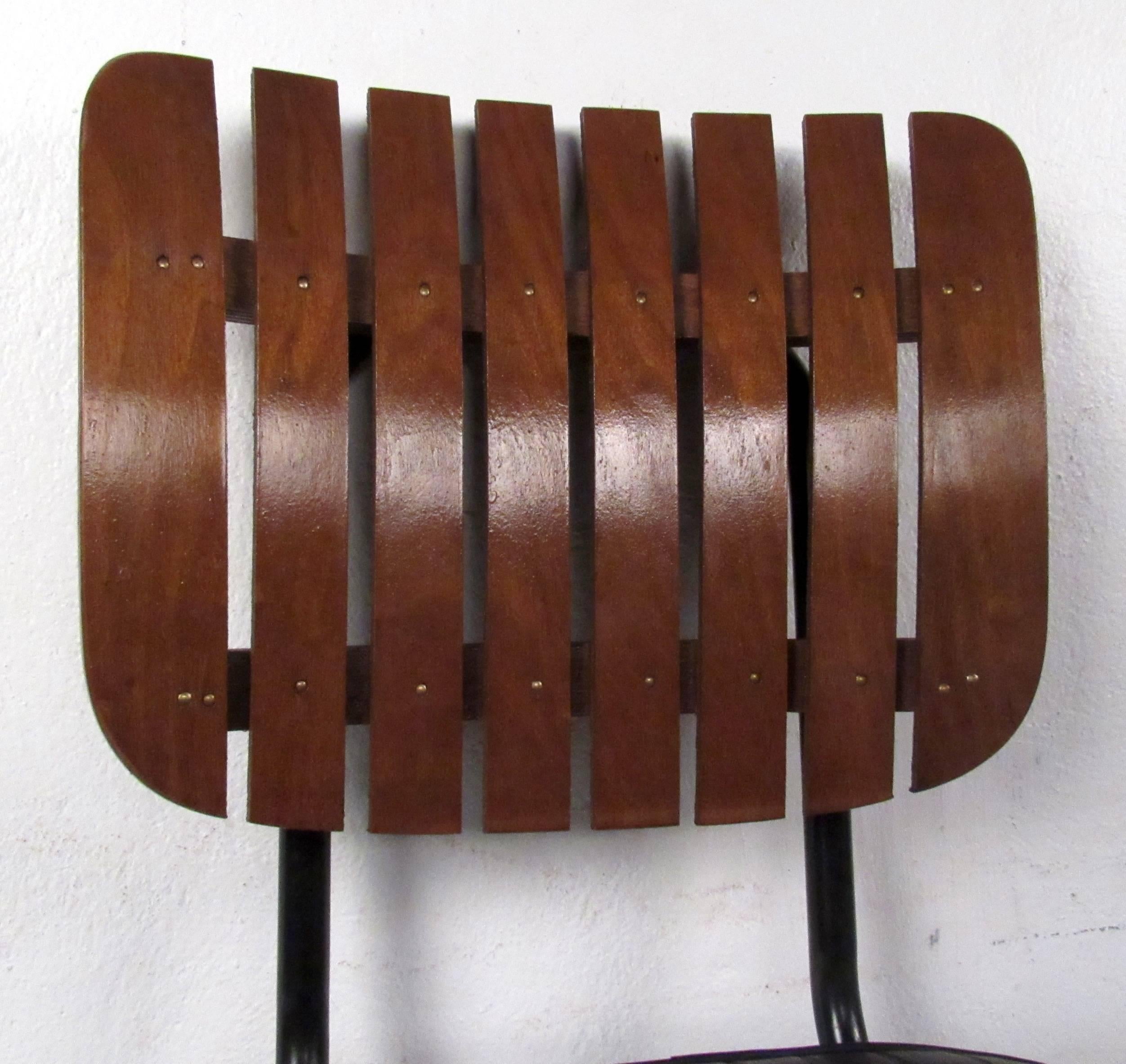 Set of vintage-modern stools featuring slat wood backs, vinyl upholstered seats, and iron bases. By Arthur Umanoff. 

Please confirm item location NY or NJ with dealer.