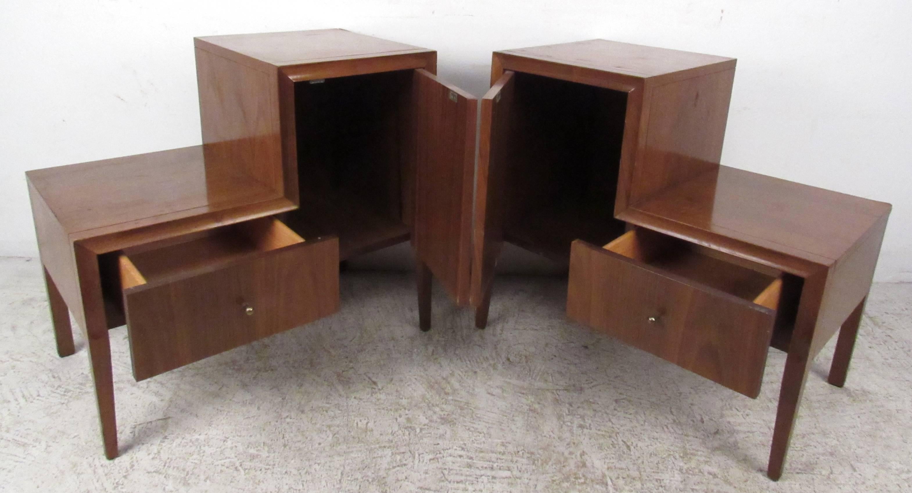 Two vintage-modern nightstands featuring unique side by side cabinet and drawer. A sleek stepside design with tapered legs, conical drawer pulls, and elegant walnut wood grain throughout. The unusual 