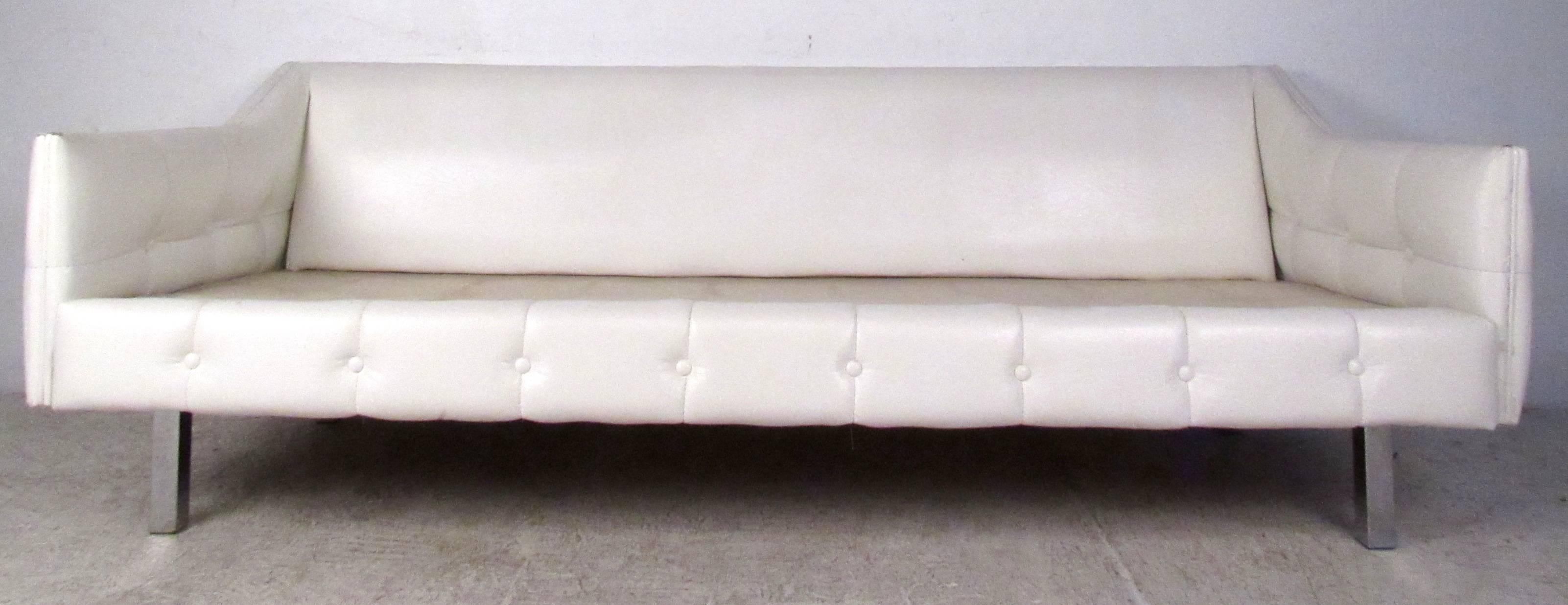 Vintage-modern sofa featuring chrome legs and tufted white vinyl upholstery with removable cushions. Funky retro style includes tufted vinyl and comfortable proportions, a great seating addition to home or business.

Please confirm item location NY