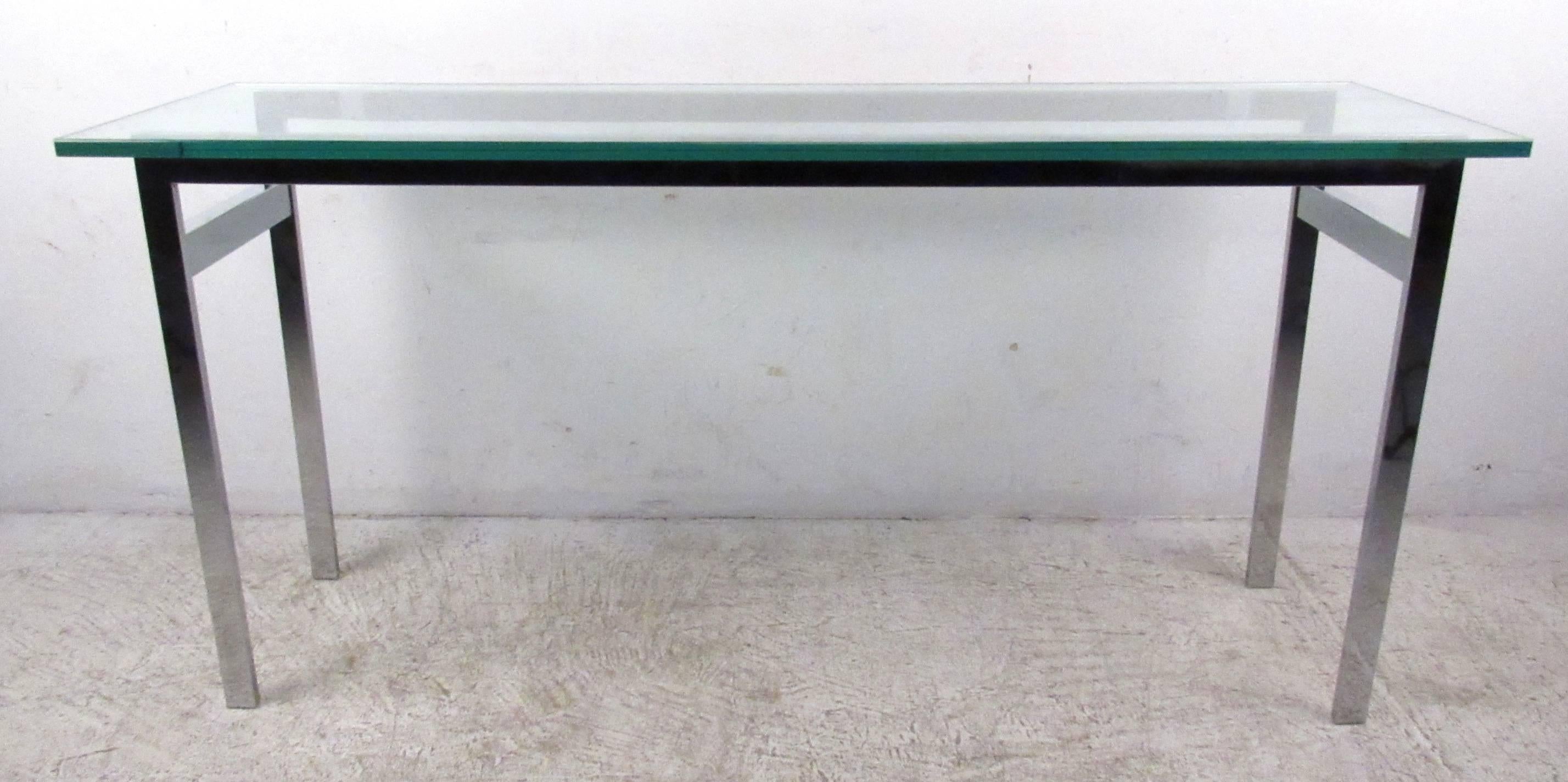 Vintage-modern console table featuring sculpted chrome base and glass top. Designed in the manner of Milo Baughman. 

Please confirm item location NY or NJ with dealer.