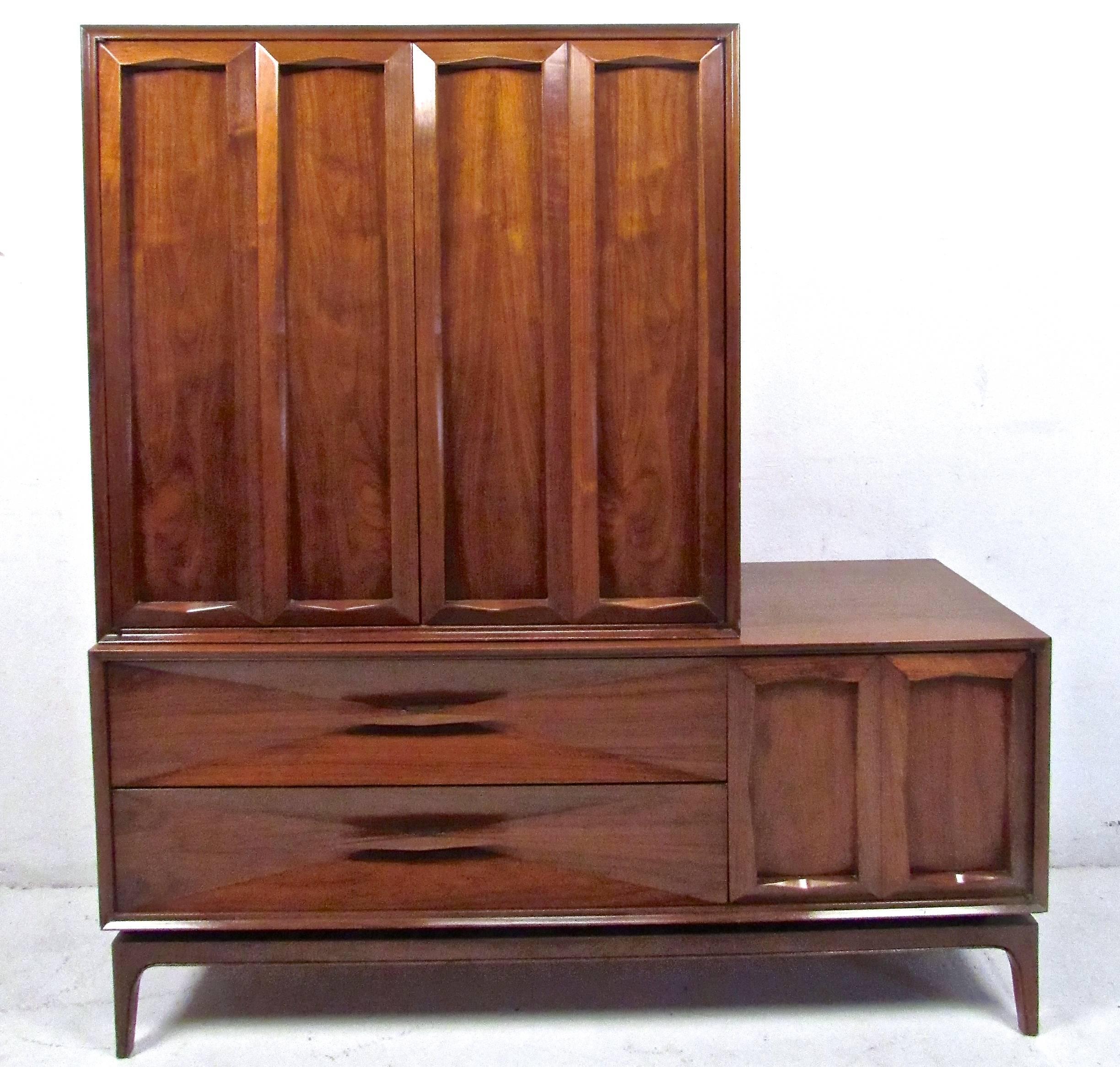 This stunning vintage walnut dresser features uniquely angled drawer fronts, tapered legs, and unique pulls. The upper cabinet features three drawers plus vertical split shelves for organization and storage. Please confirm item location (NY or NJ).
