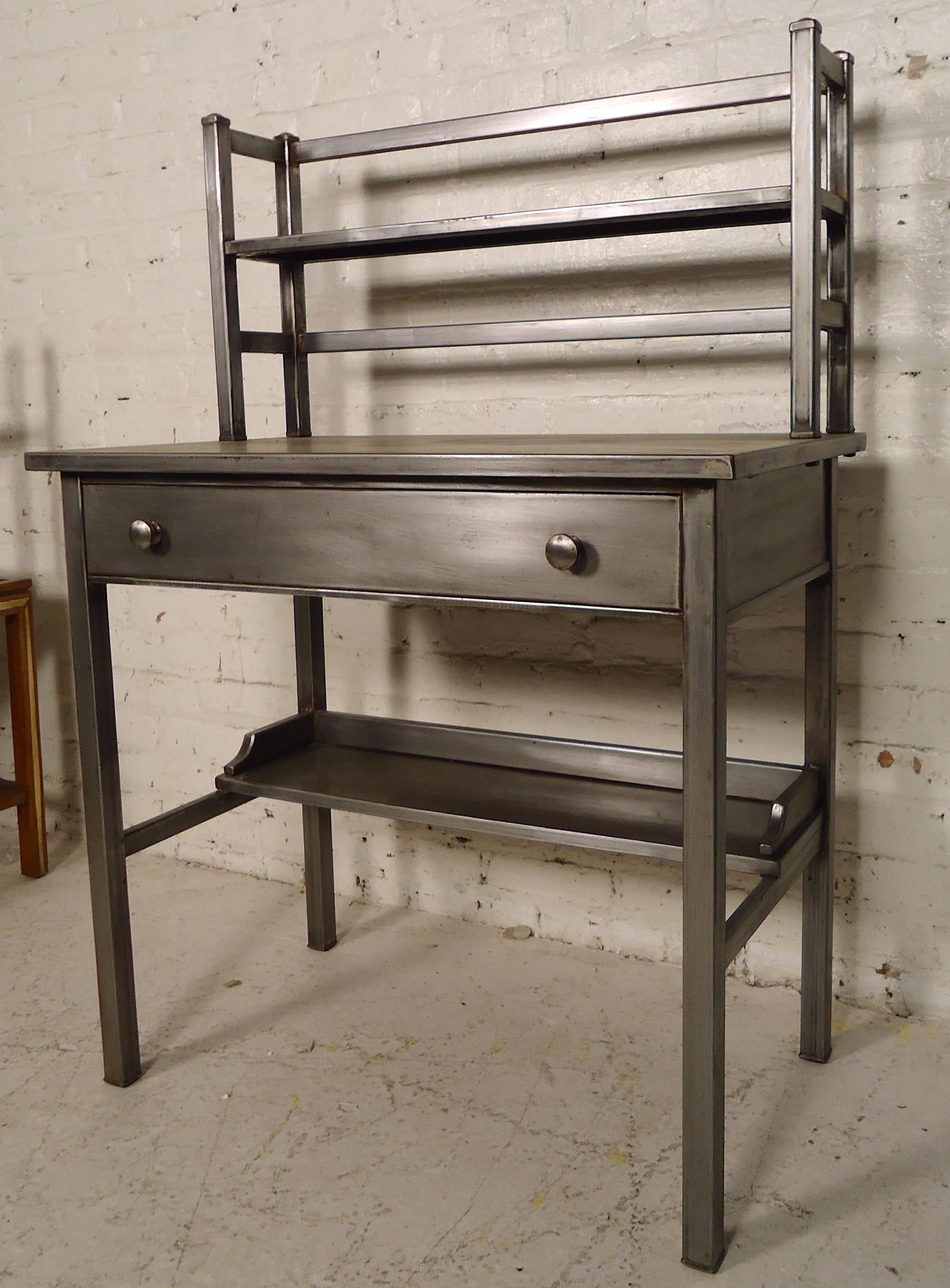 Striking metal desk restored in a bare metal style finish. Attaches bookshelf, bottom footrest and wide drawer.
Kneehole measures: 27" W, 9" D, 23" H.

(Please confirm item location - NY or NJ - with dealer).
 