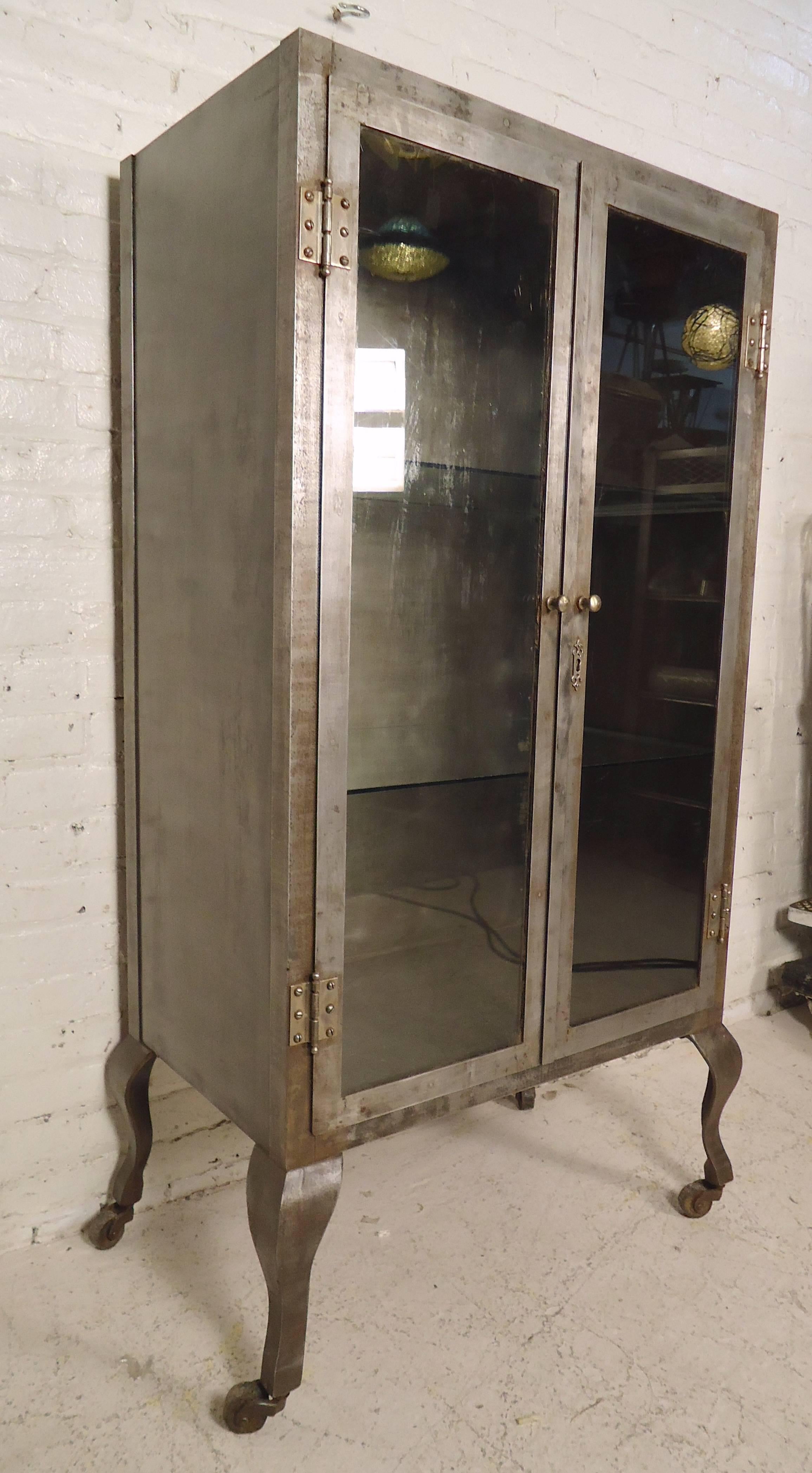 Unique display cabinet restored in an attractive industrial style finish. Two glass doors, two glass shelves (with space for four), rolling casters. Great for bathroom, or kitchen storage.

(Please confirm item location - NY or NJ - with