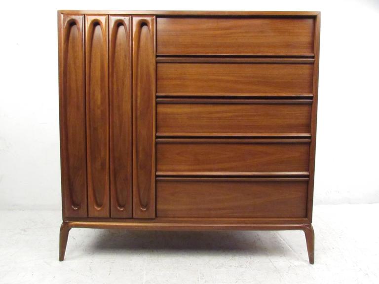 This unique American walnut dresser features stunning vintage craftsmanship, evident in it's simple yet elegant details. From rounded corner tapered legs to sculpted cabinet front, this impressive ten drawer dresser offers ample storage for any