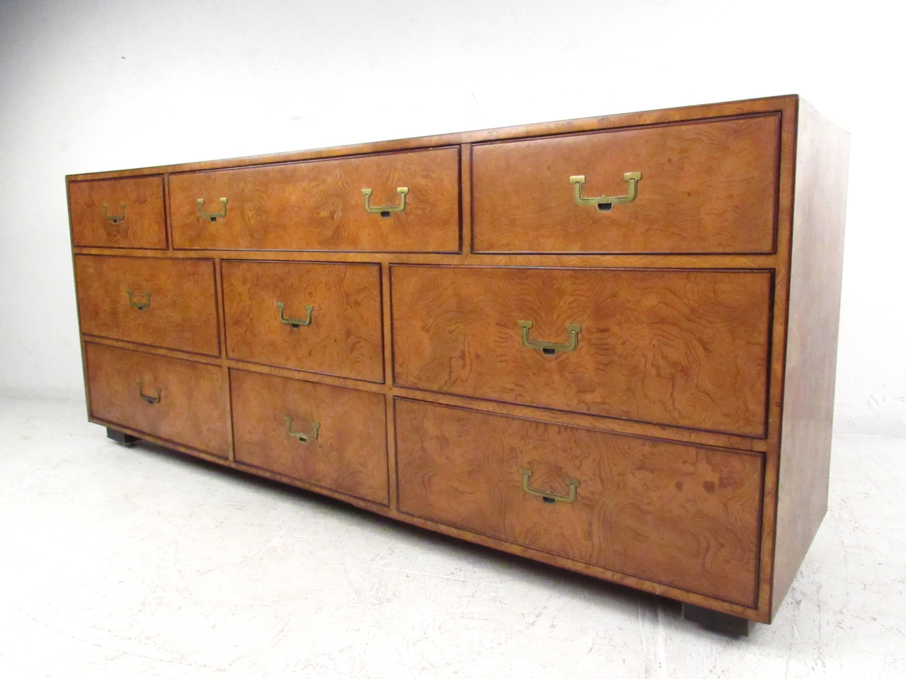 This beautiful vintage burl wood dresser features nine different sized drawers, complete with brass Campaign style handles. Stunning vintage finish is complimented by the unique lines of the piece, original manufacturer's label in drawer. Please