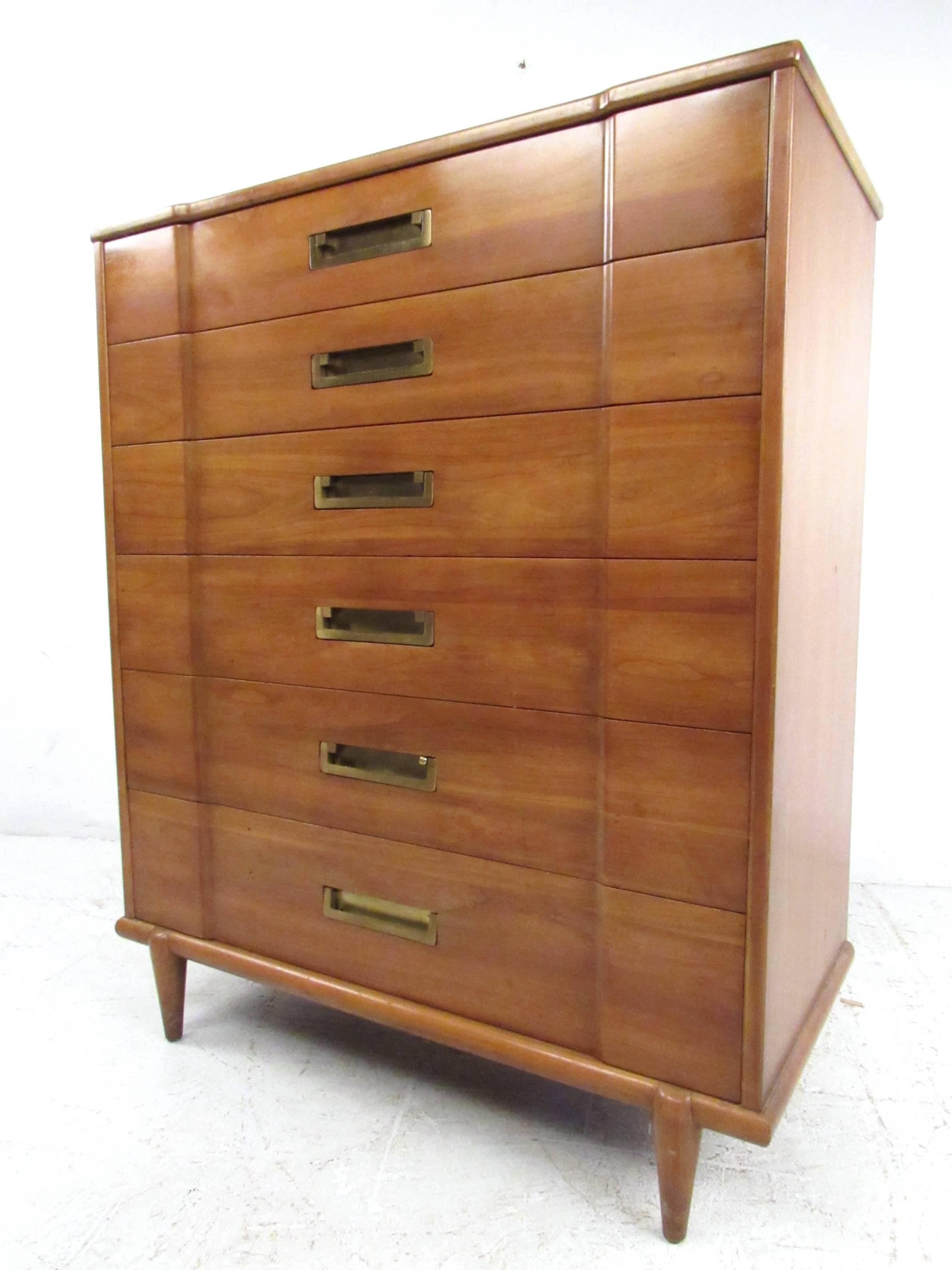 This beautiful six-drawer dresser by John Widdicomb makes a statuesque addition to any interior. Unique tapered legs, Campaign style brass hardware, and textured drawer fronts add to it's vintage charm. Original manufacturer's mark in drawer. Please