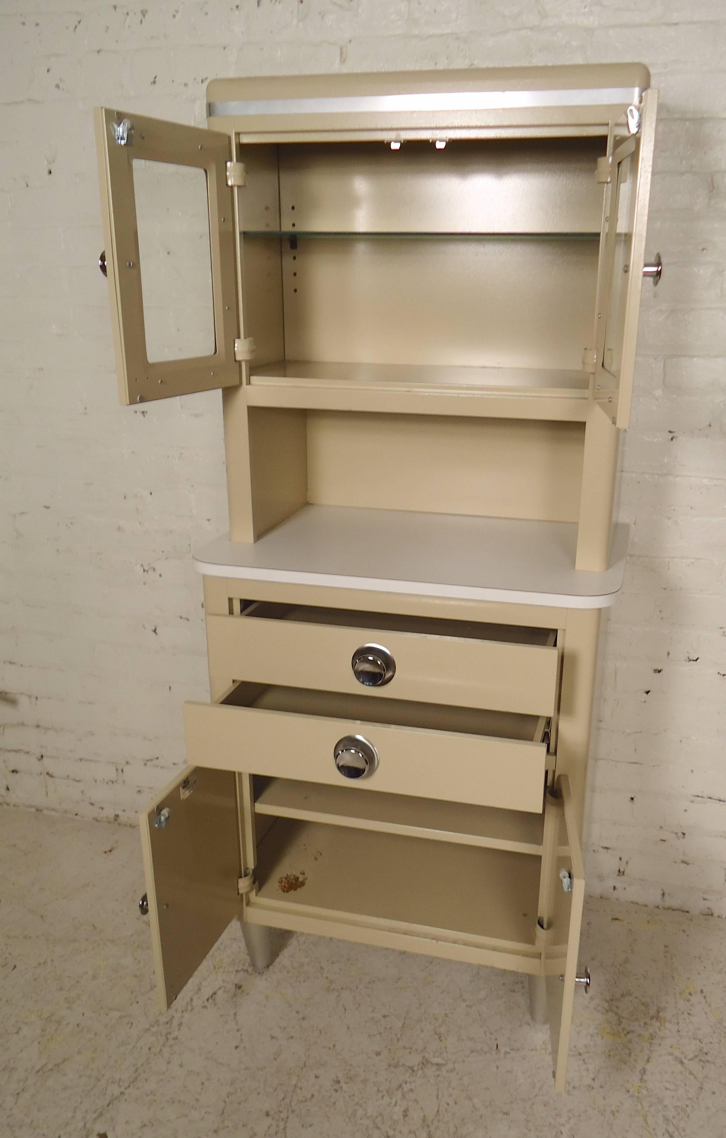 Examination room storage cabinet in great original condition. Glass door cabinet, drawers and lower cabinet storage. Polished chrome handles, tapered legs. Makes an attractive bathroom or kitchen storage unit.

(Please confirm item location - NY