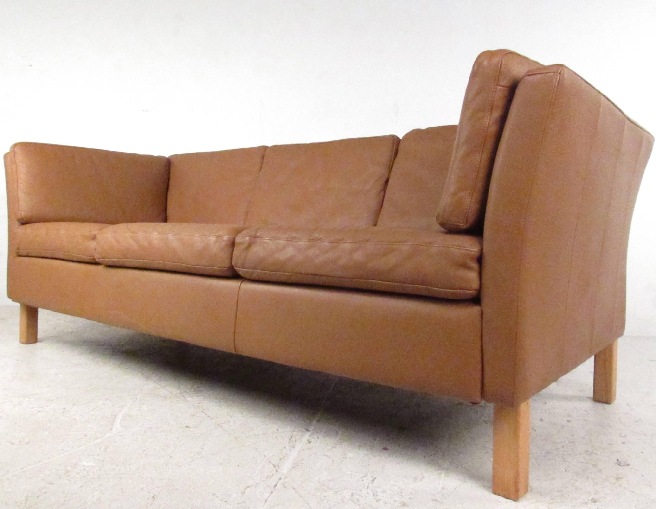 This classic Mid-Century leather three-seat sofa features the simple modern lines Scandinavian Modern design is so well known from. Danish modern design and comfortable upholstery make this a stylish seating option for home, office, or business use.