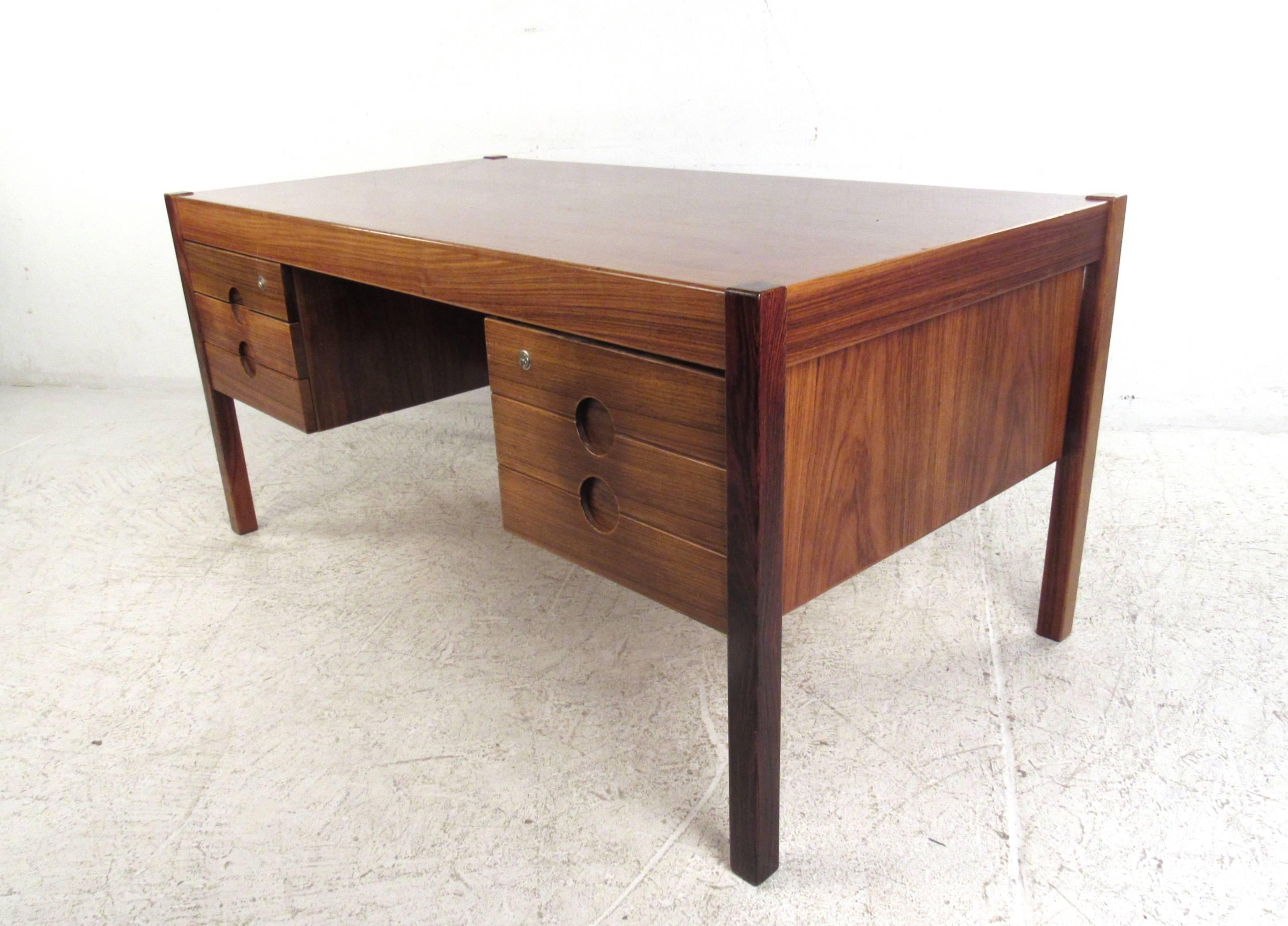 This unique Indian rosewood desk by Mid-Century Danish designer Christian Linneberg makes a stylish and unique workplace for any interior. Double-sided desk features ample drawer space for storage as well as a rear side shelf for display. Please