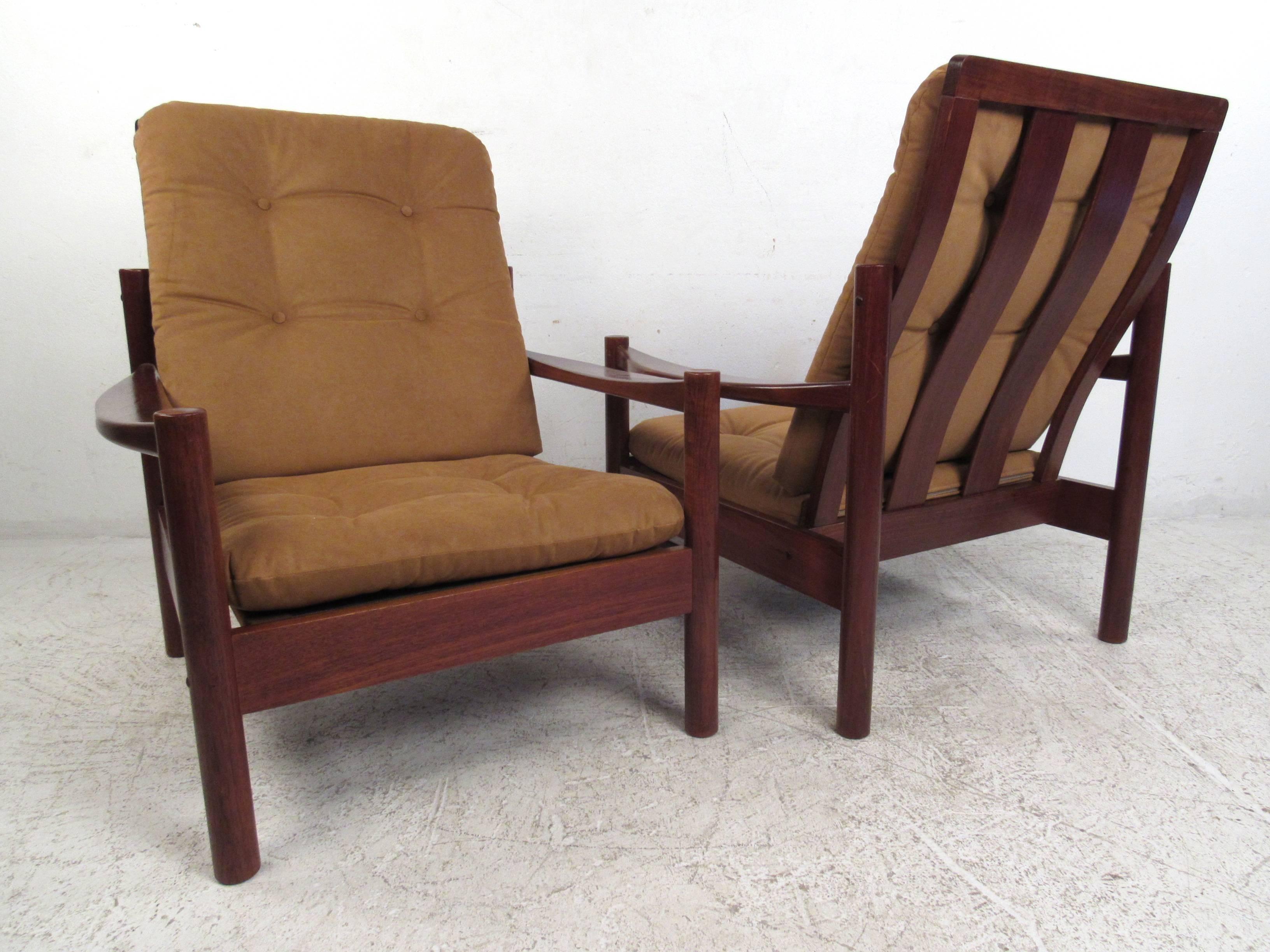 This tufted pair of vintage teak armchairs feature unique Danish modern design, with tufted upholstery and sculpted armrests. The removable cushions are covered in plush light brown fabric. Stylish bentwood vertical backs perfectly compliment the