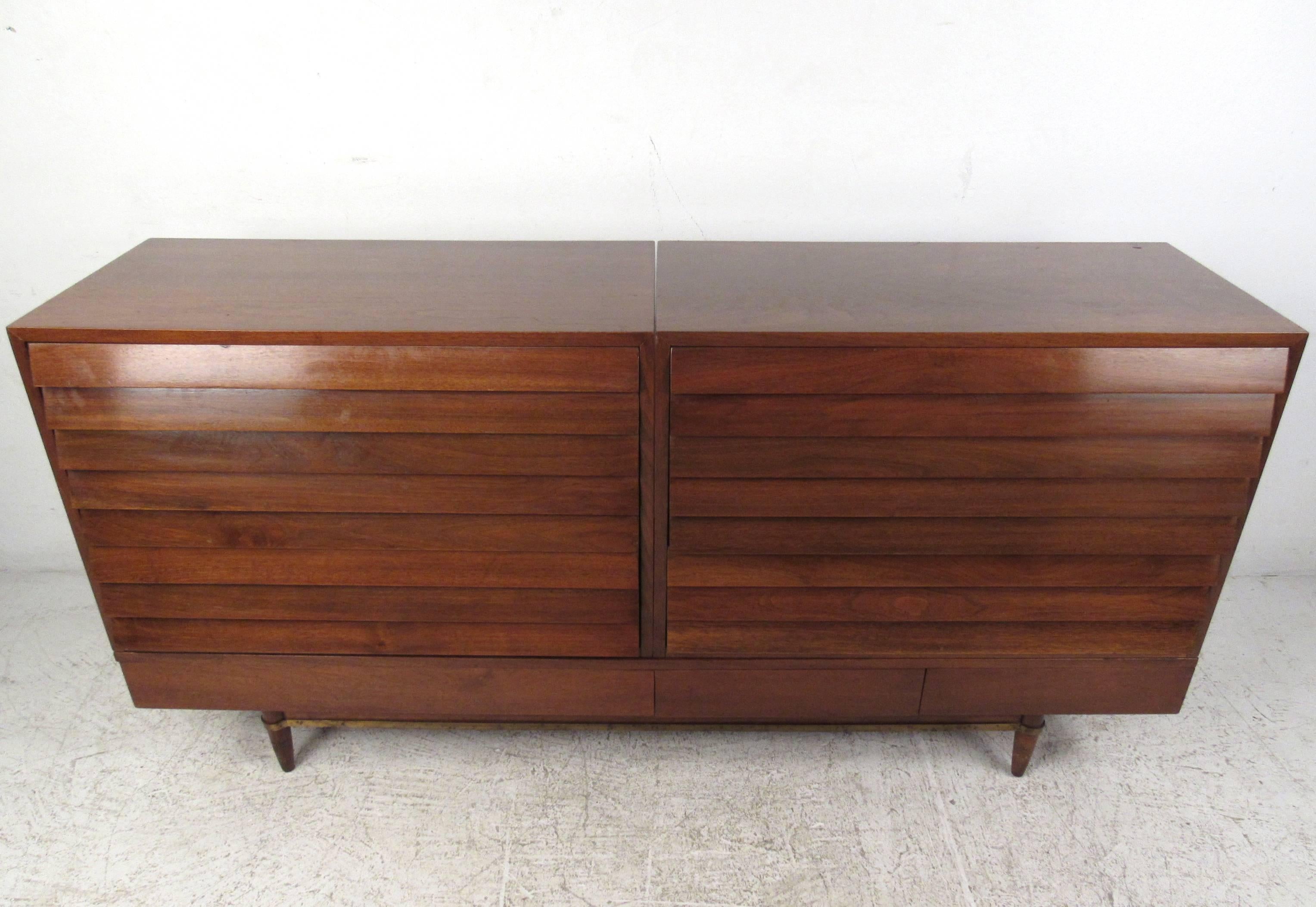 This unique Mid-Century Modern American walnut dresser consists of three separate pieces that configure wonderfully into this nine drawer piece. Two-three drawer louvered cabinets rest on top of the low coffee table style three drawer base. Rich