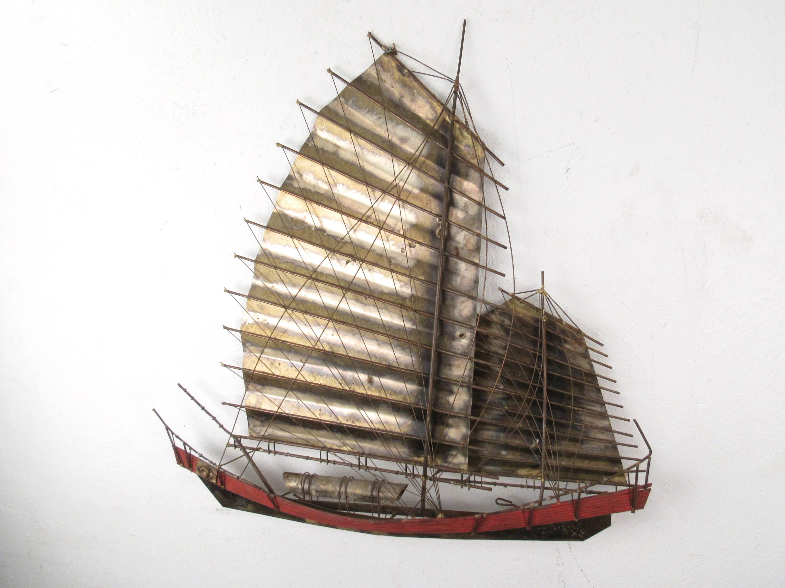 This unique Mid-Century metal wall sculpture depicts a stunning Chinese junk boat. Its mixture of painted finish, patinated metal and wire rigging add to the charm of this signed piece. Original signature visible 
