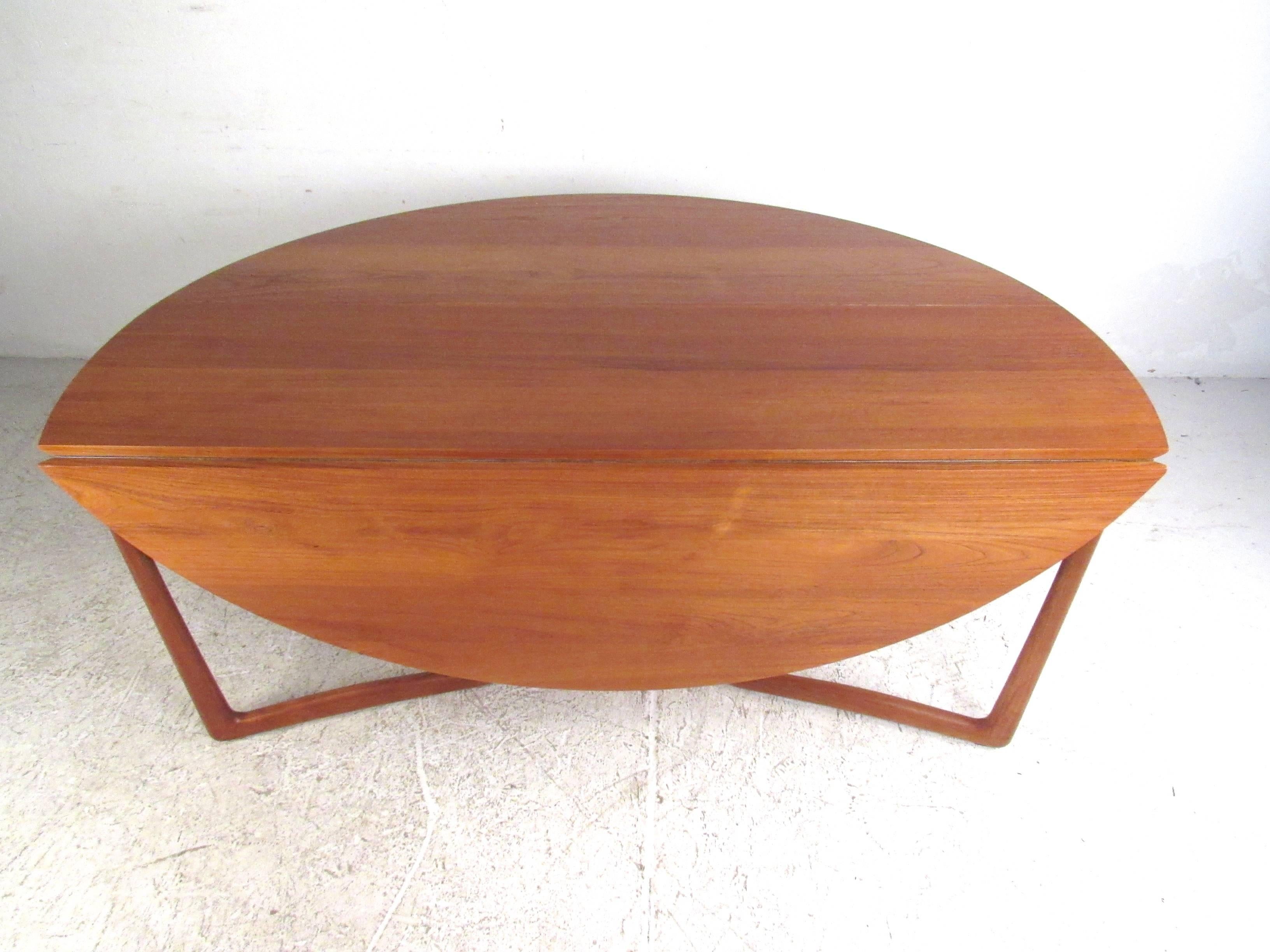 Cette superbe table du milieu du siècle présente une combinaison parfaite de design vintage élégant et de fonctionnalité. Les deux feuilles tombantes sont dotées de pieds sculptés qui se rétractent facilement pour atteindre une largeur de 18