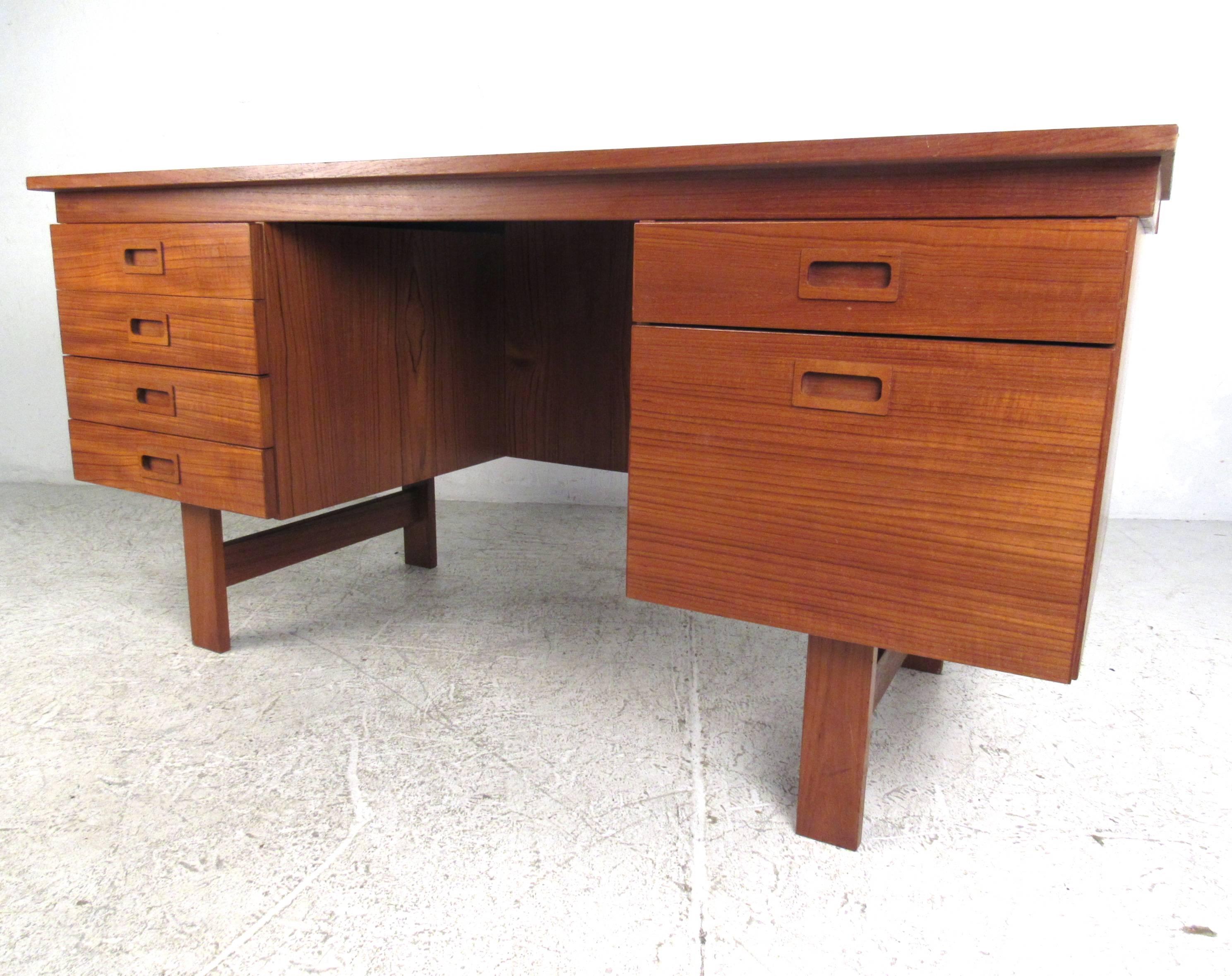 This Danish modern writing desk features a rich natural teak finish, spacious workspace, and plenty of drawers for storage. Manufactured by Vi-Ma mobler in Denmark, the mid-century style of the desk makes it a wonderful addition to any modern