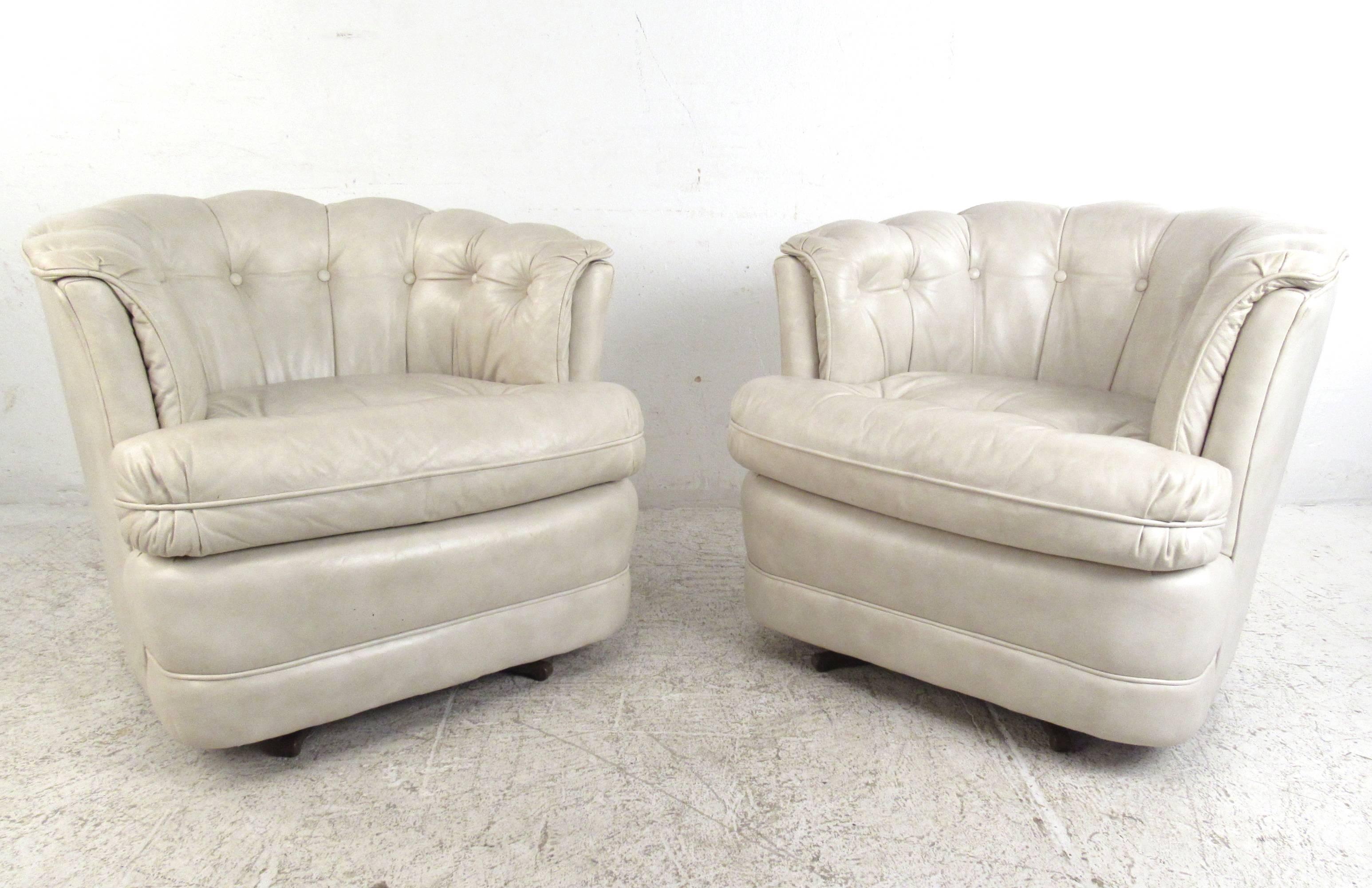 This Mid-Century pair of tufted white leather swivel chairs by Classic Leather (USA) provides the perfect mix of comfort and style. Comfortable upholstery with their barrel back shape is wonderfully accented by the vintage style of the pair. Swivel