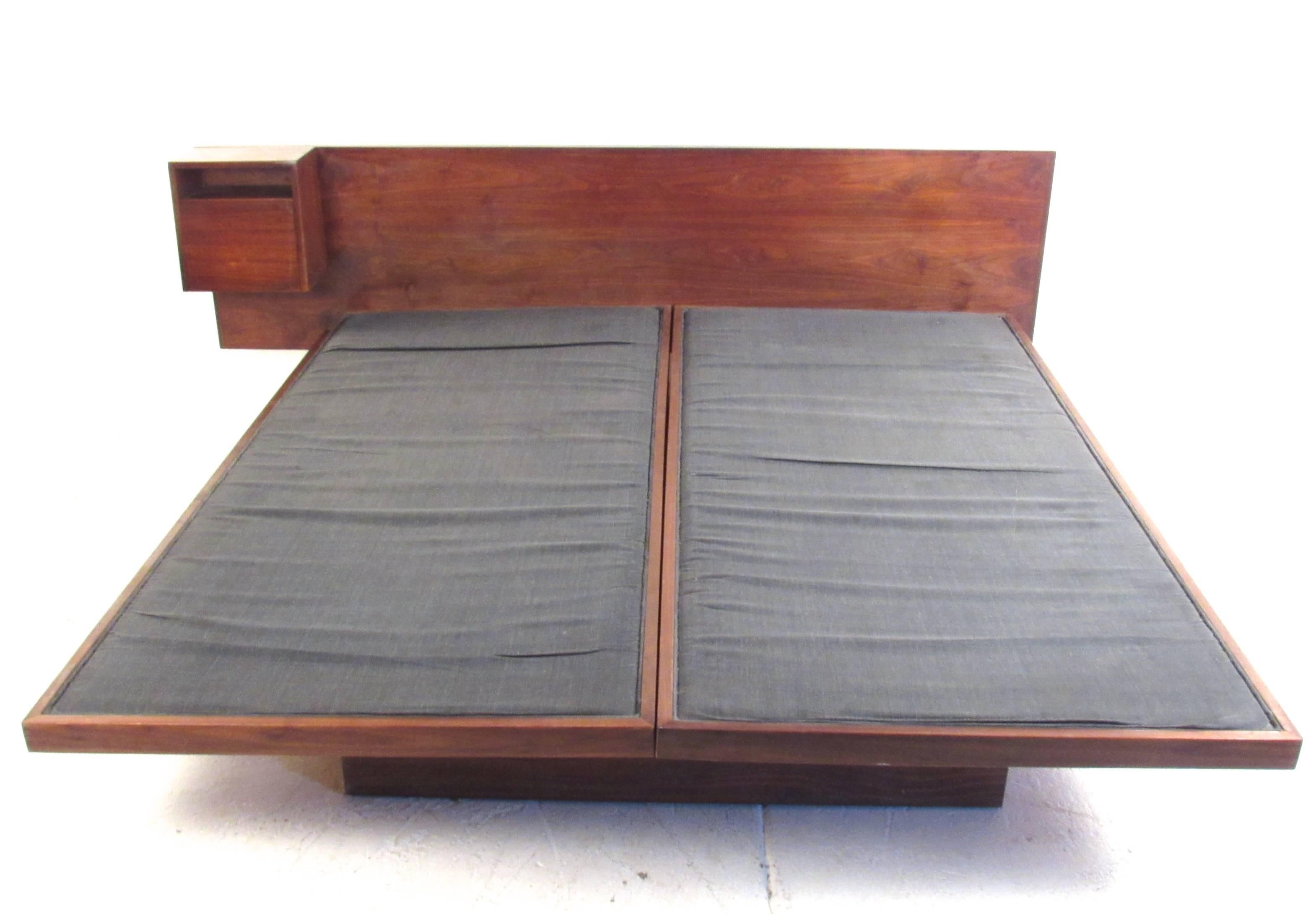 This unique teak platform bed features vintage hardwood king-size headboard with a mounted teak end table. Drop-front cabinet with added cubby for storage makes a convenient bedside storage compartment which the impressive size of this Mid-Century