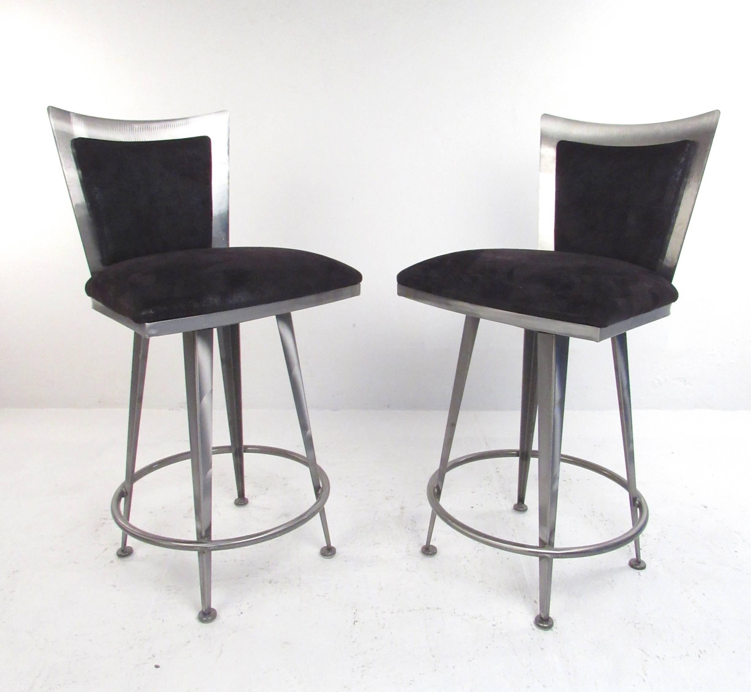 This unique set of three heavy metal barstools features a shapely Italian style design with plush upholstered seats. Swivel seats, tapered legs and circular footrest add to the stylish modern appeal of the stools. Please confirm item location (NY or