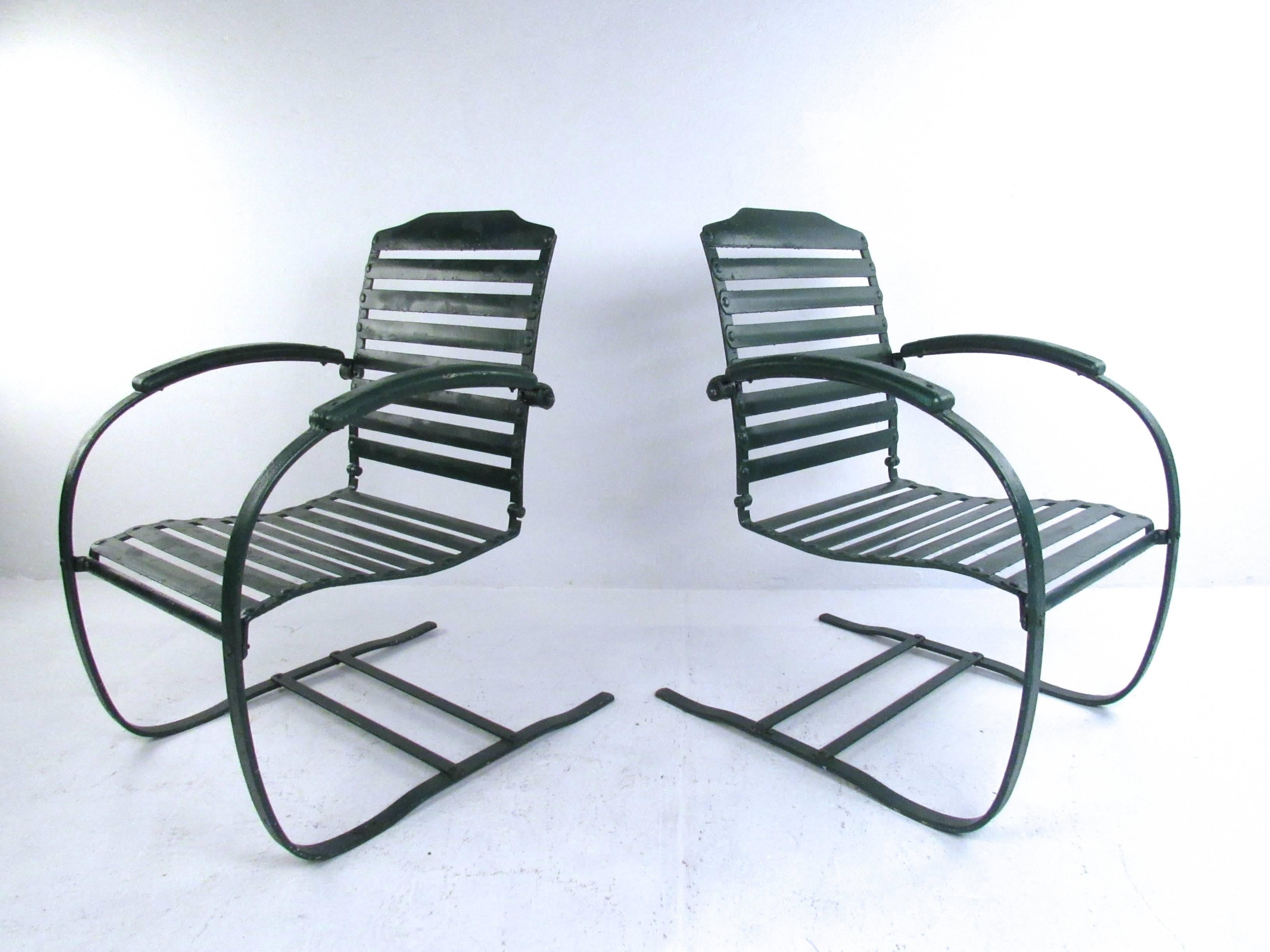 This vintage pair of patio chairs features sturdy metal construction with horizontal slat seat and back. Rounded cantilever spring style frames make a stylish impression for any home, garden or patio. Please confirm item location (NY or NJ).