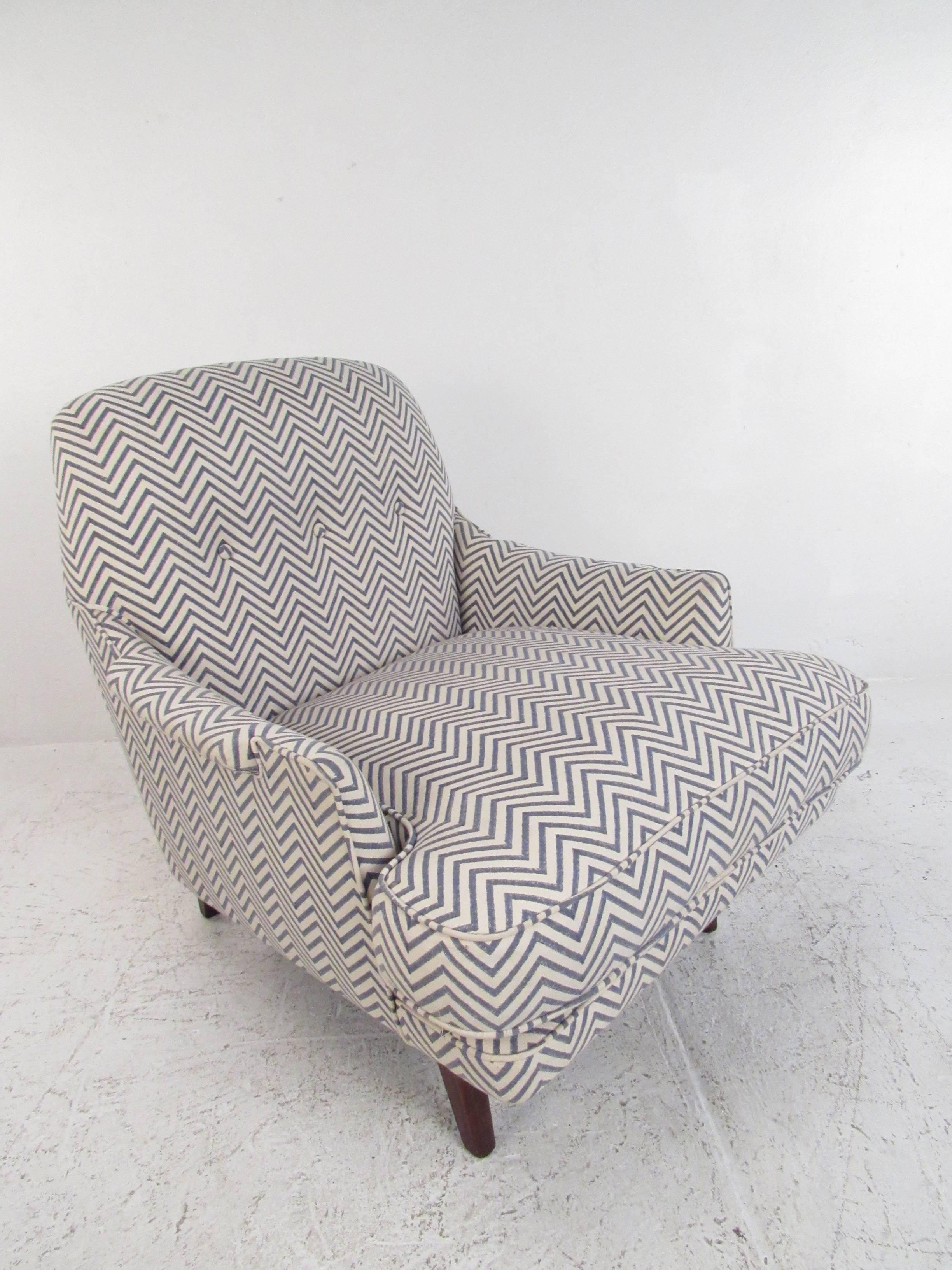 This uniquely shaped vintage lounge chair features rounded seat back, tufted upholstery, and a matching vintage ottoman. Unique padded armrests add to the stylish charm of this vintage Roger Sprunger chair, making it perfect for home or lounge use.