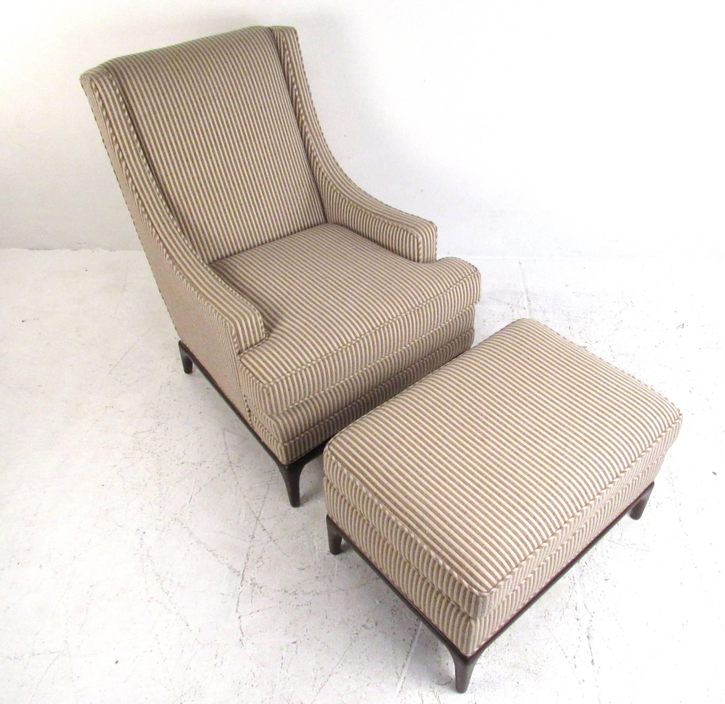 This vintage lounge chair features a unique sculpted design with high seat back and low-profile armrests. Tapered hardwood bases and vintage fabric add to the Mid-Century appeal of this Robsjohn-Gibbings style chair with matching ottoman. Please