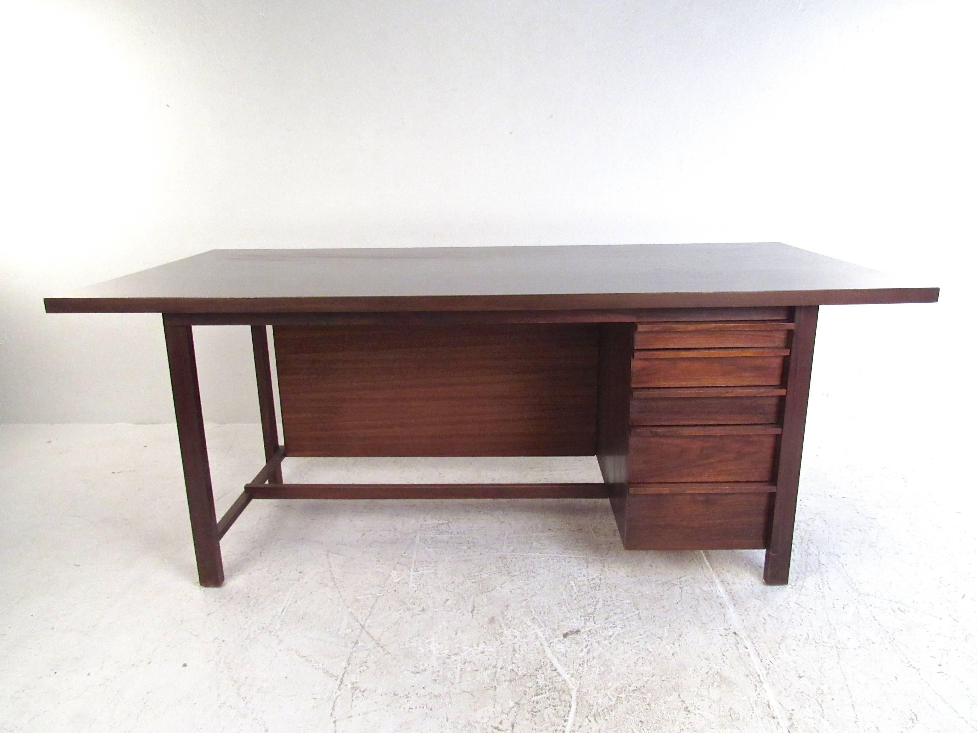 This stunning large-scale executive desk features a spacious worktop with sturdy hardwood frame. Unique Mid-Century Knoll style is wonderfully displayed through carved drawer pulls and unique cane front design. Elegant yet versatile desk for home or
