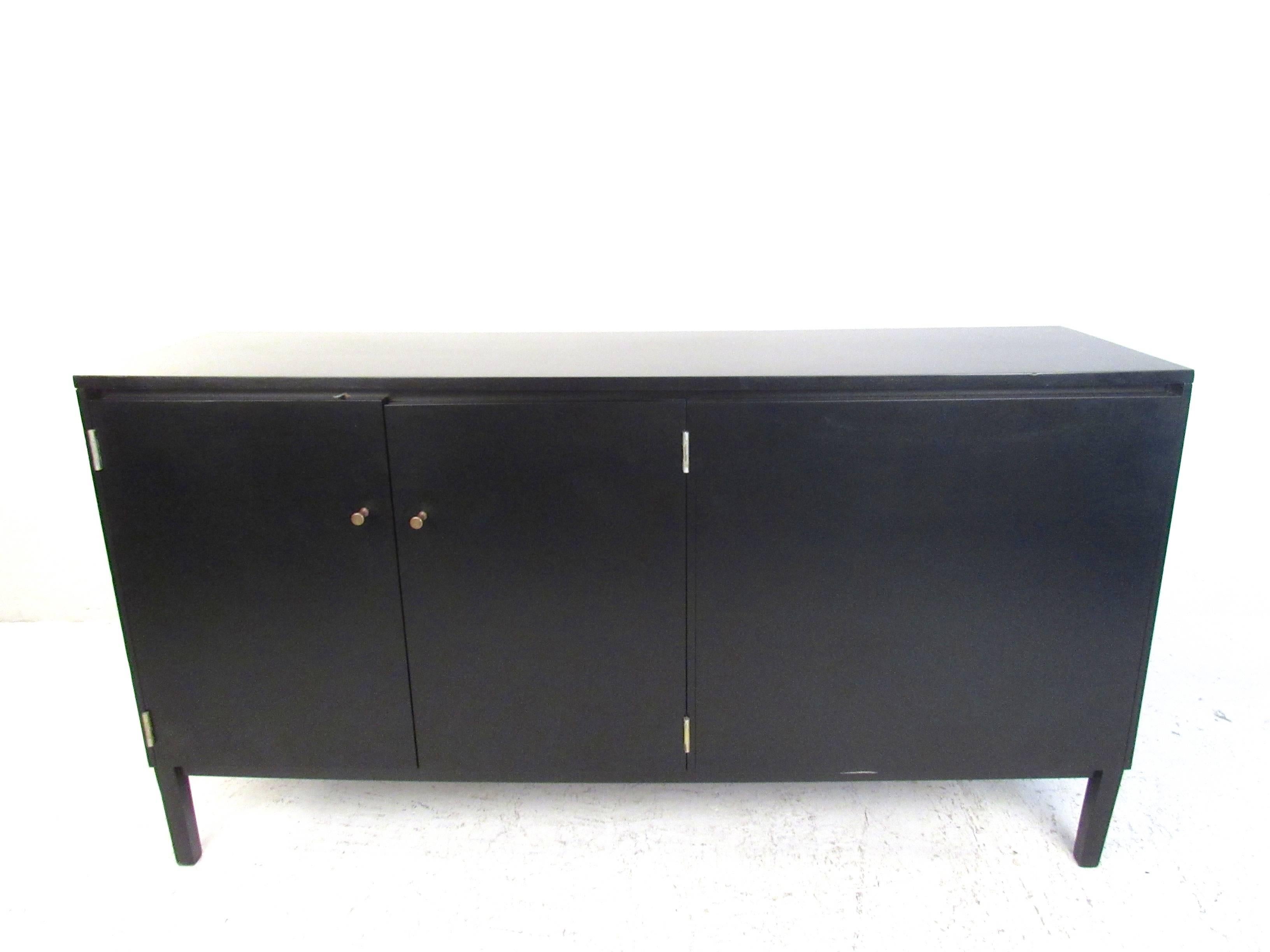 This vintage Paul McCobb Perimeter Group credenza features double-sided cabinets, drawers for storage, and unique ebonized finish. Classic McCobb drawer pulls add to it's unique Mid-Century appeal. Perfect piece as an office room divider with