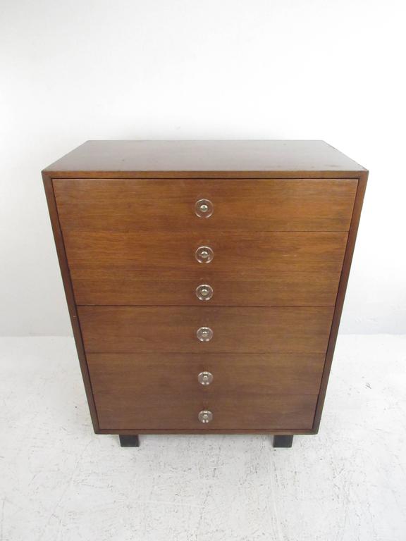 This Mid-Century highboy dresser features a beautiful array of vintage details, from the immediately recognizable block legs George Nelson used throughout much of his work, to the unique Lucite and brass drawer pulls. Plenty of style and storage