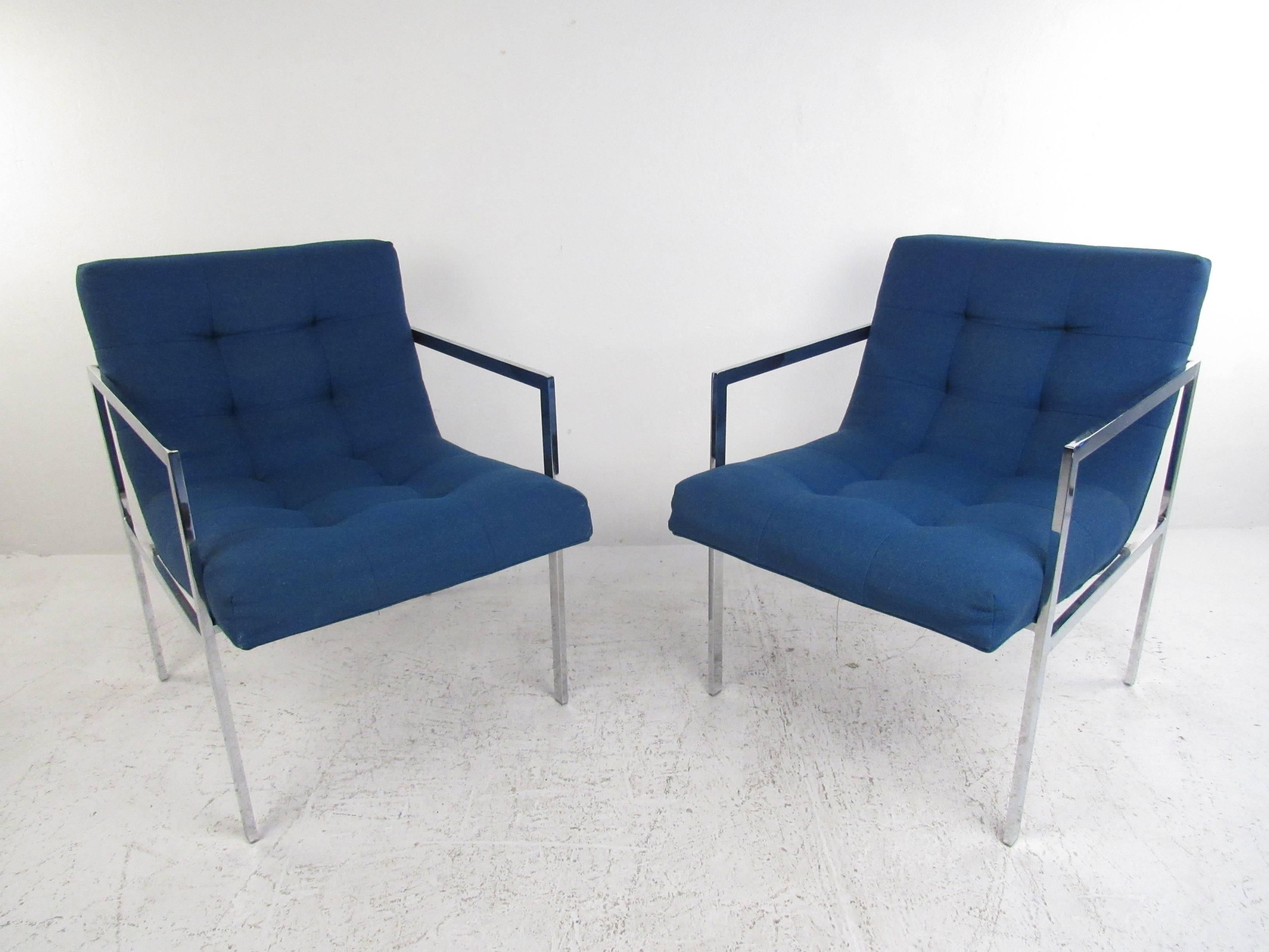 This pair of vintage chrome frame armchairs feature plush upholstery with a uniquely designed seat back for added comfort. Tufted buttons add to the unique Mid-Century style of the pair, while simple metal frames wonderfully compliment the pair.