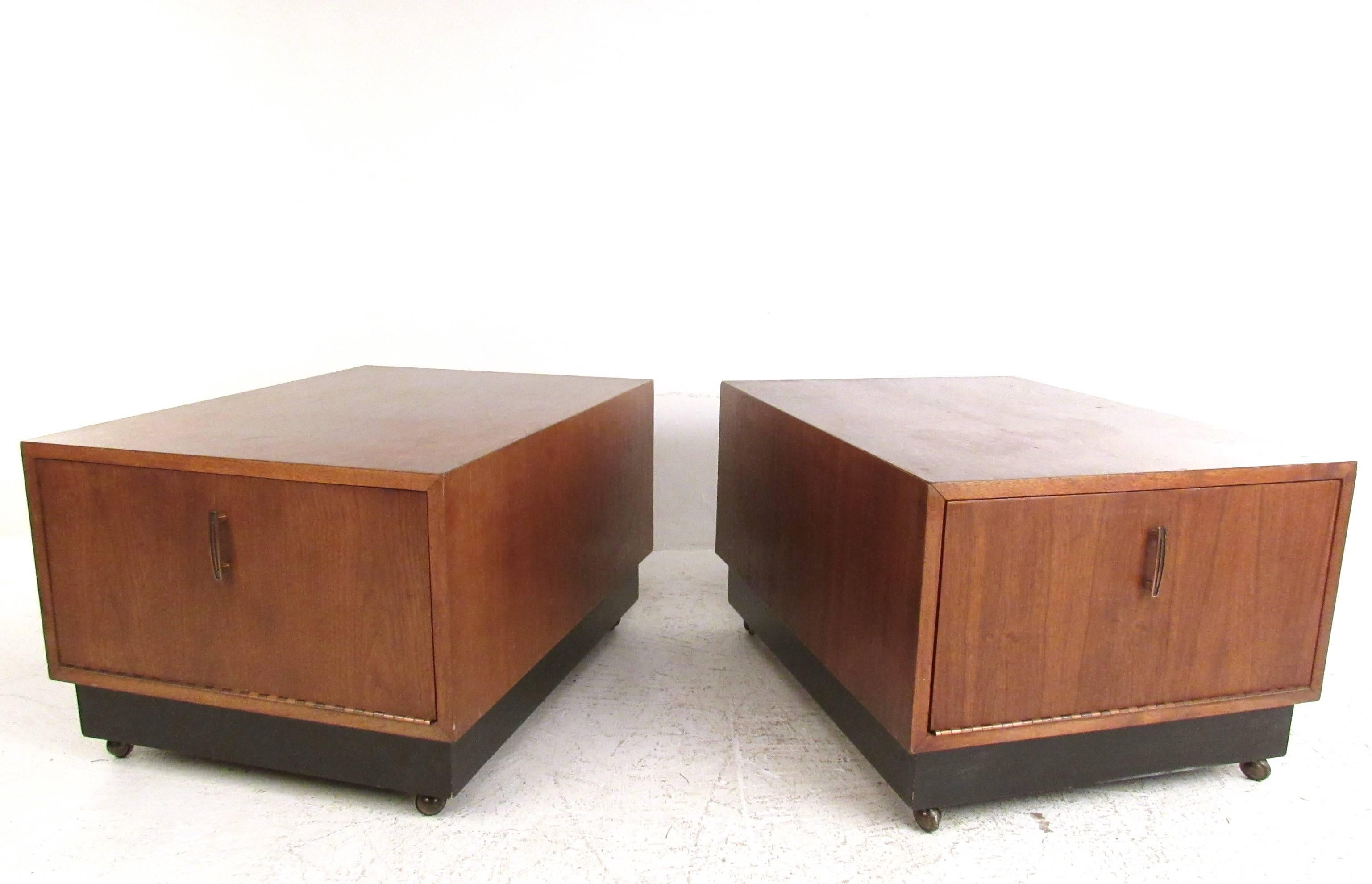 This pair of rolling end tables feature spacious drop front cabinet space for ample storage in any setting. Stylish design with vintage handles feature a beautiful walnut finish and are conveniently fitted with casters for ease of movement. Please