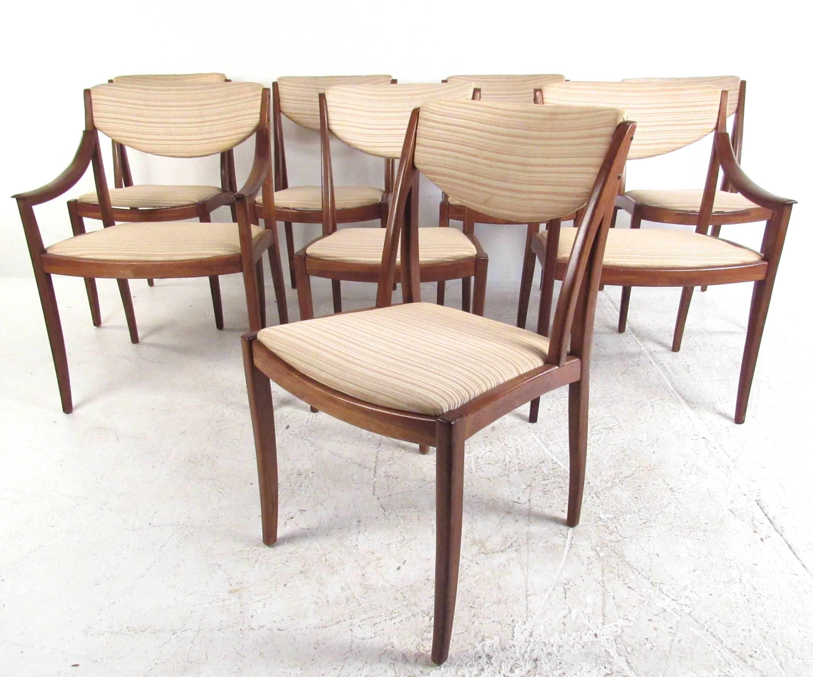 This set of eight vintage walnut dining chairs includes two armchairs and six side chairs. Comfortable and sturdy tapered frames feature upholstered/padded seats and seat backs. Unique Mid-Century style makes these chairs a beautiful addition to any