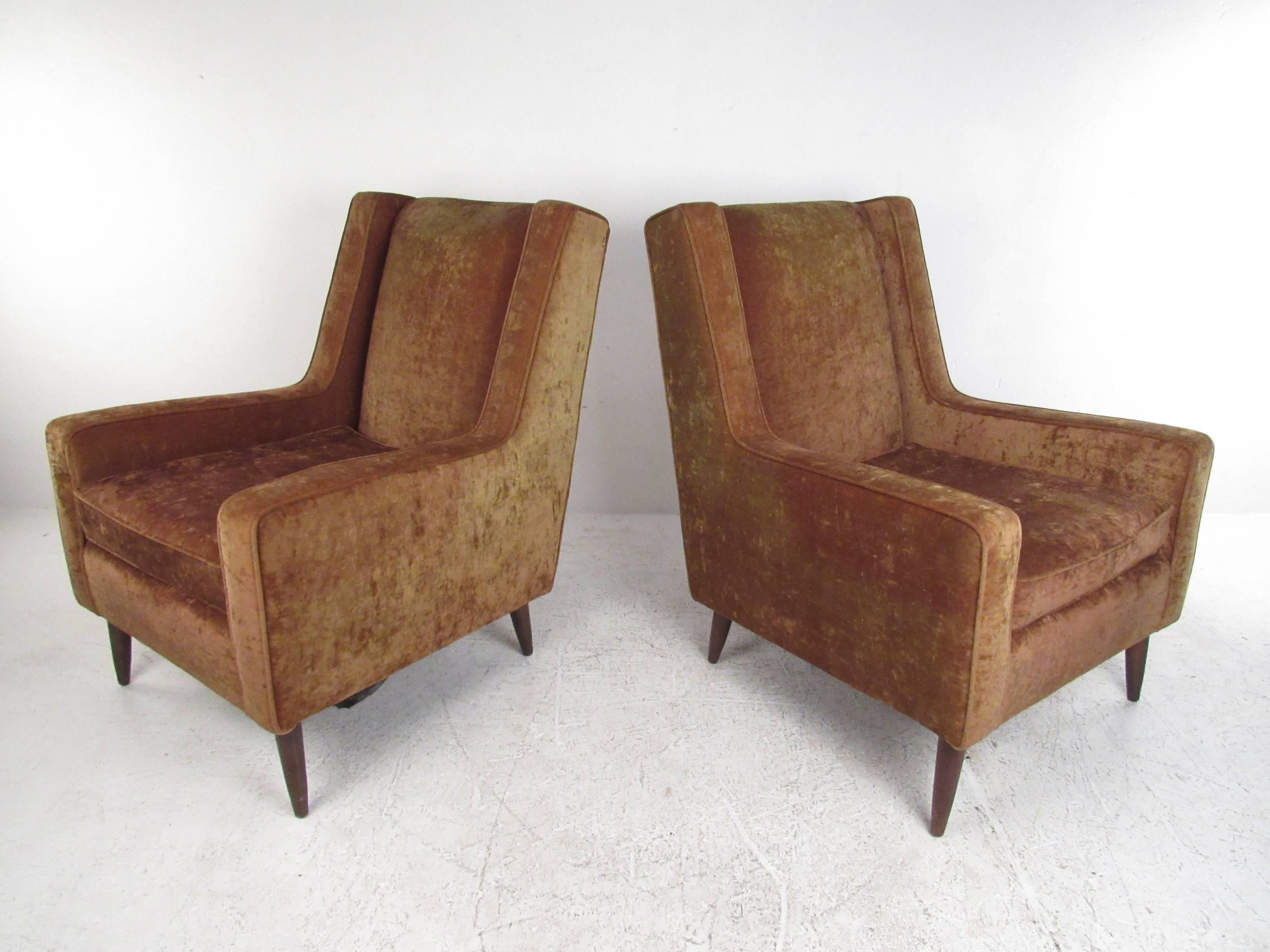 This matching pair of vintage lounge chairs features plush velvet fabric, tapered legs and clean/comfortable lines reminiscent of Mid-Century master Paul McCobb. Unique set of Mid-Century Modern armchairs make a stylish addition to any setting.